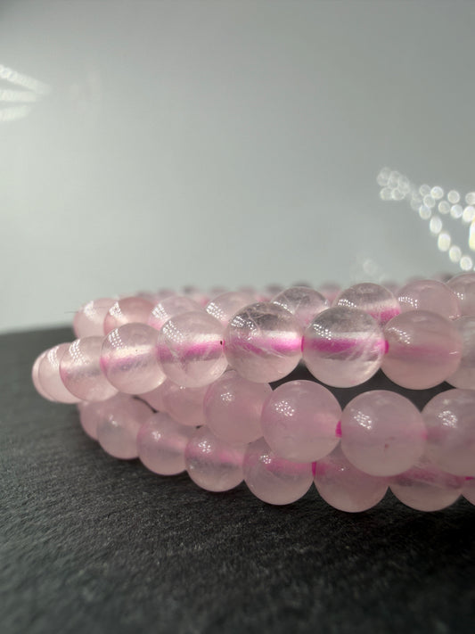 Zartrosa Kugelarmband aus poliertem Rosenquarz auf elastischem Band für Kinder.