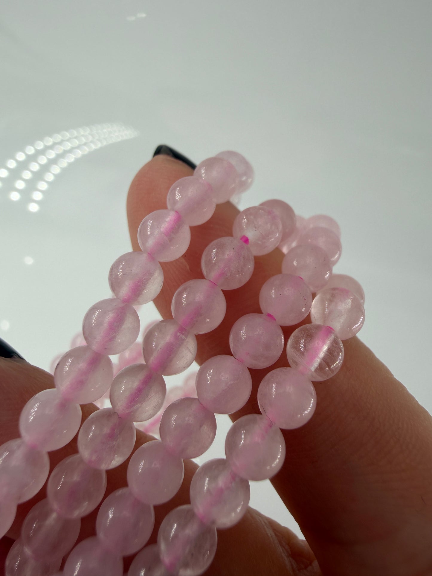 Zartrosa Kugelarmband aus poliertem Rosenquarz auf elastischem Band für Kinder.