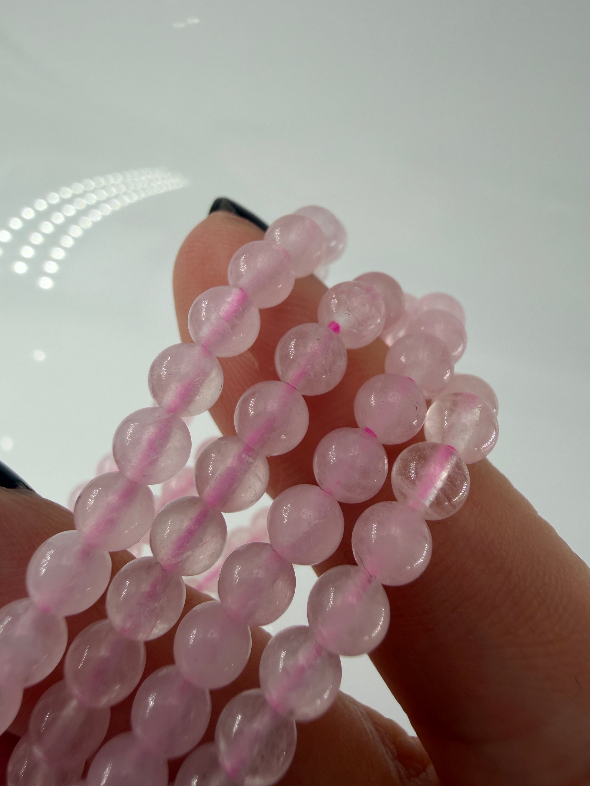 Zartrosa Kugelarmband aus poliertem Rosenquarz auf elastischem Band für Kinder.