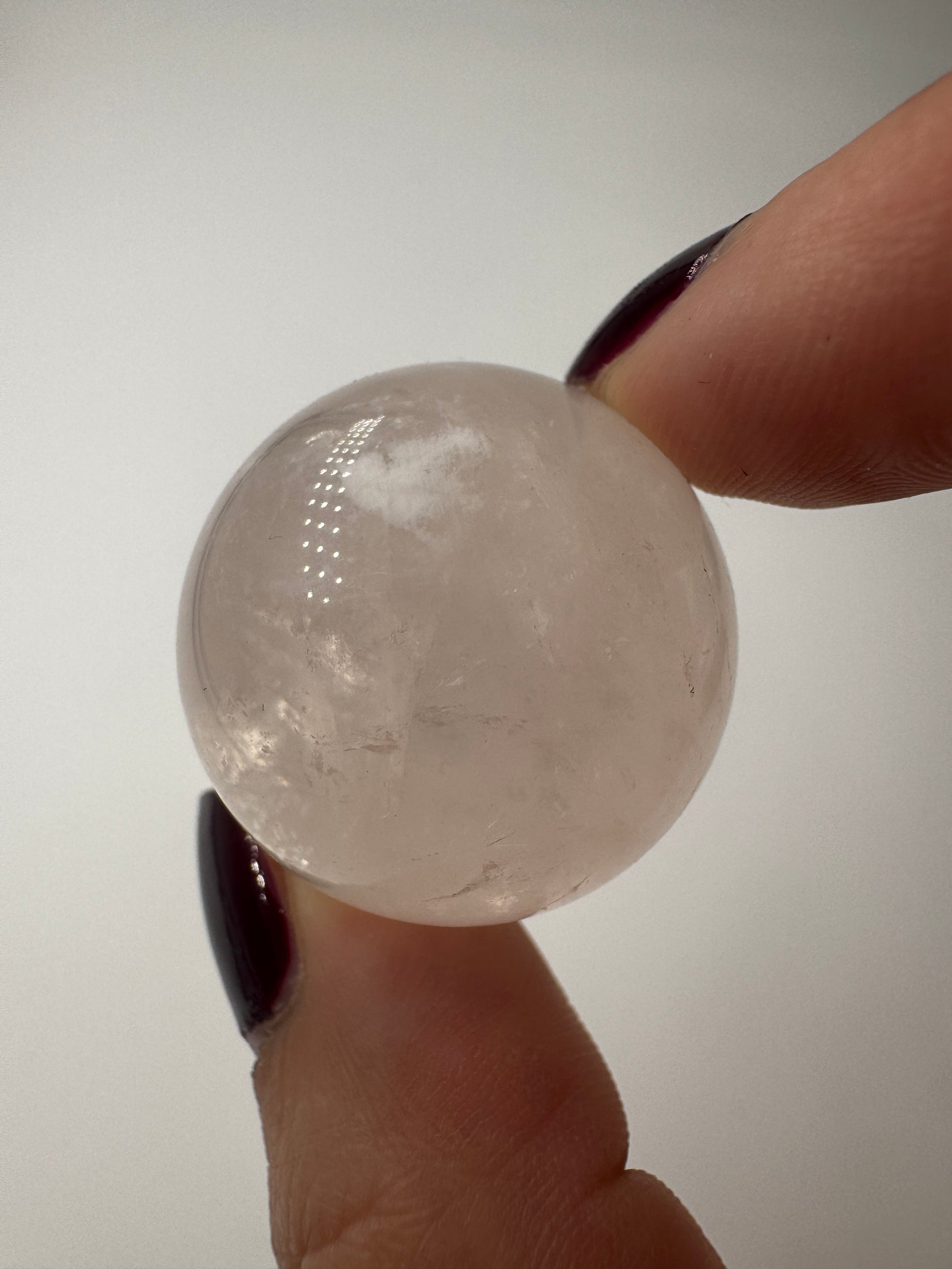 Rosenquarz-Kugel in Zartrosa mit weißen Einschlüssen, Ø 2,7 cm.