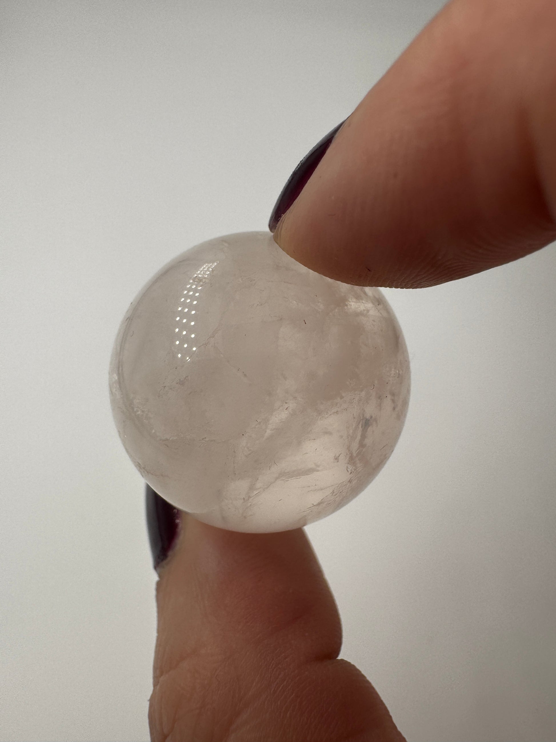 Rosenquarz-Kugel in Zartrosa mit weißen Einschlüssen, Ø 2,7 cm.