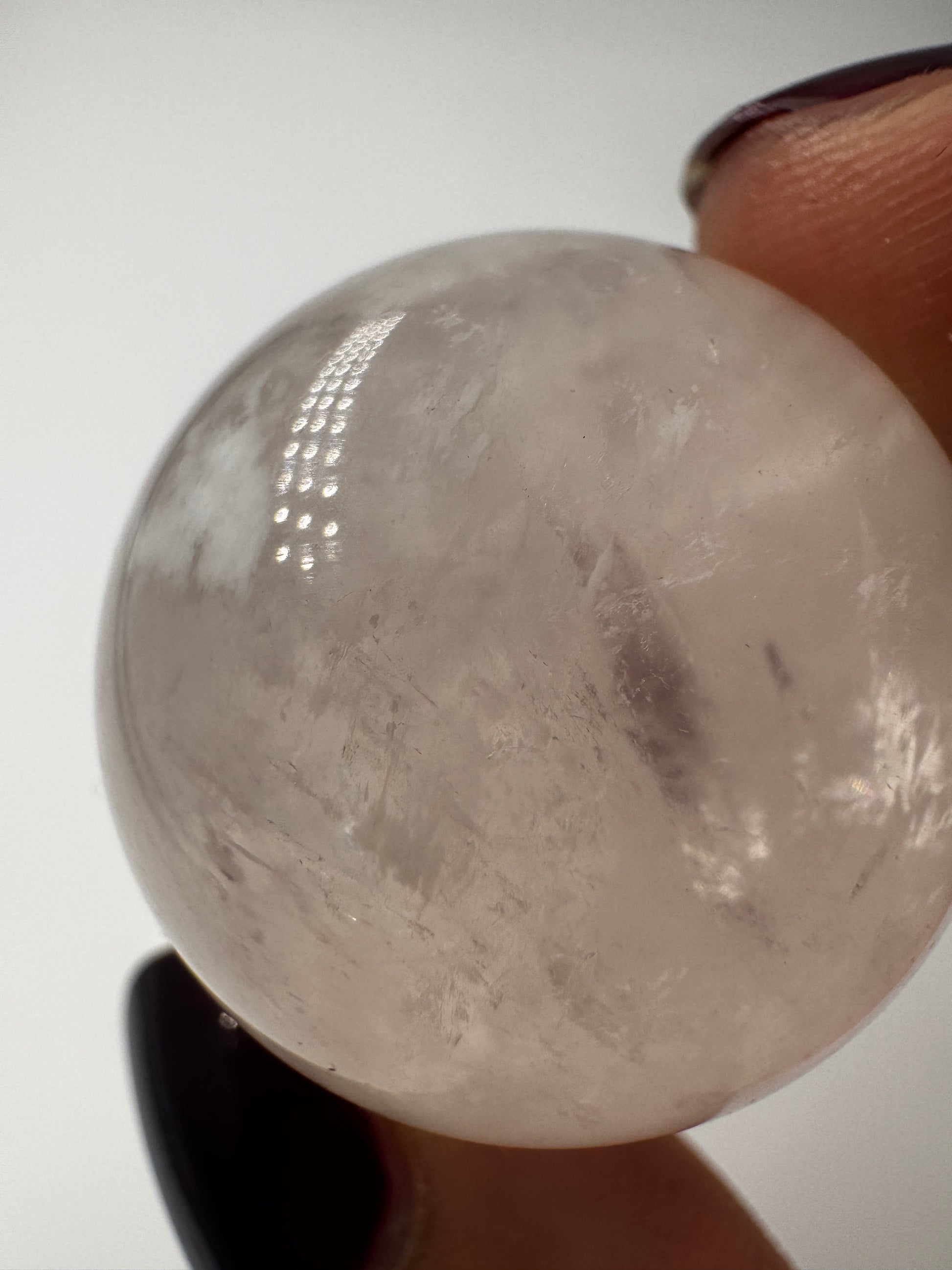 Rosenquarz-Kugel in Zartrosa mit weißen Einschlüssen, Ø 2,7 cm.