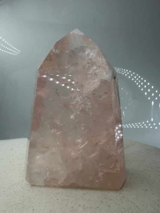 Polierte Rosenquarz-Spitze aus Brasilien mit sanfter rosa Färbung und glänzender Oberfläche.