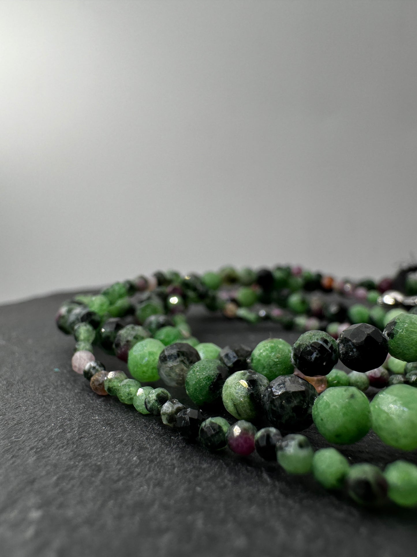Armband aus Rubin in Zoisit mit Facettperlen – kontrastreiches Rot-Grün-Schwarz-Muster aus Korund, Zoisit und Hornblende.
