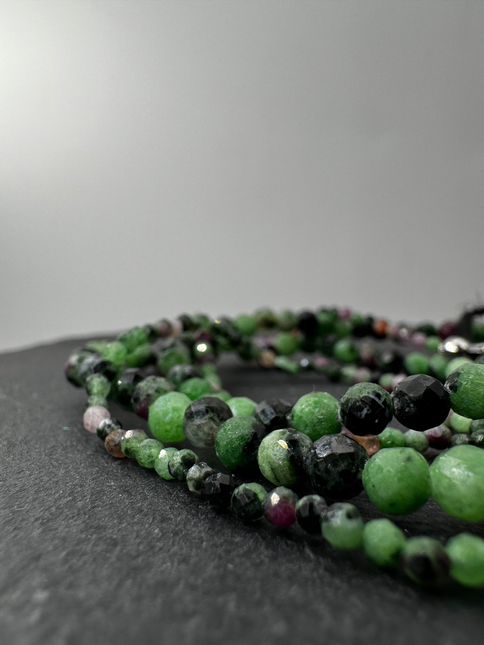 Armband aus Rubin in Zoisit mit Facettperlen – kontrastreiches Rot-Grün-Schwarz-Muster aus Korund, Zoisit und Hornblende.