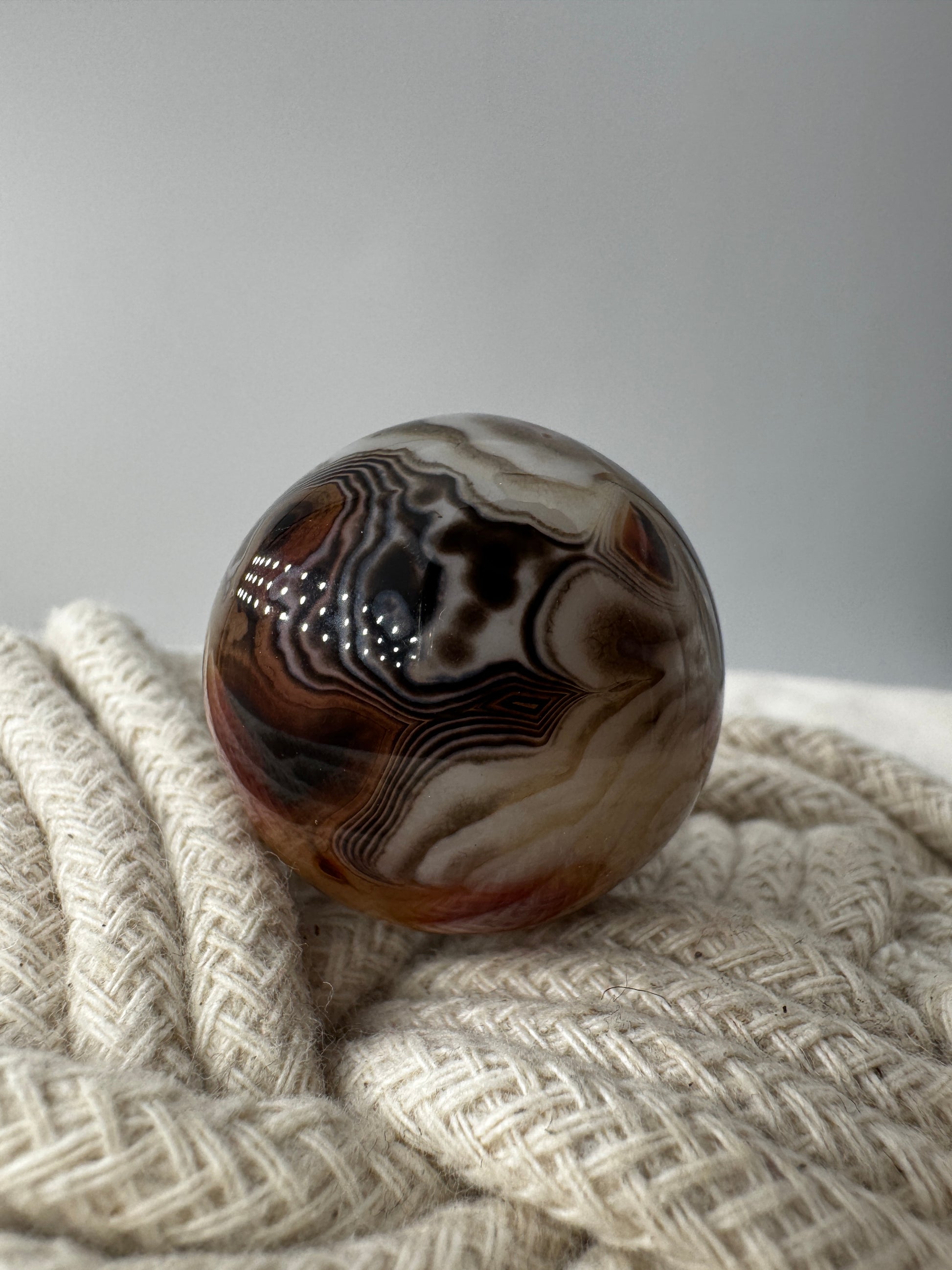 Eine hochglanzpolierte Kugel aus Sardonyx mit charakteristischer Bänderung.