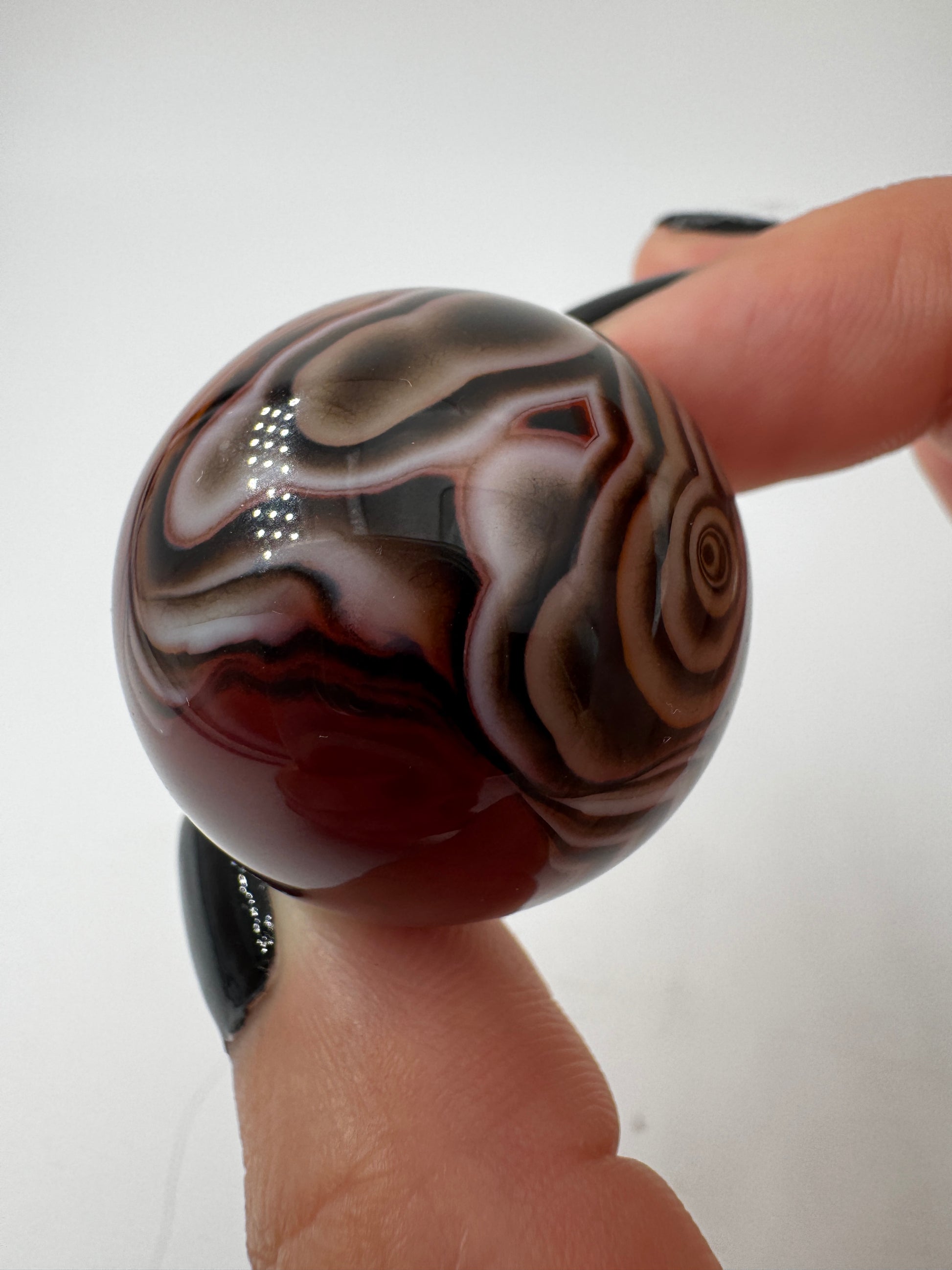 Eine hochglanzpolierte Kugel aus Sardonyx mit charakteristischer Bänderung.
