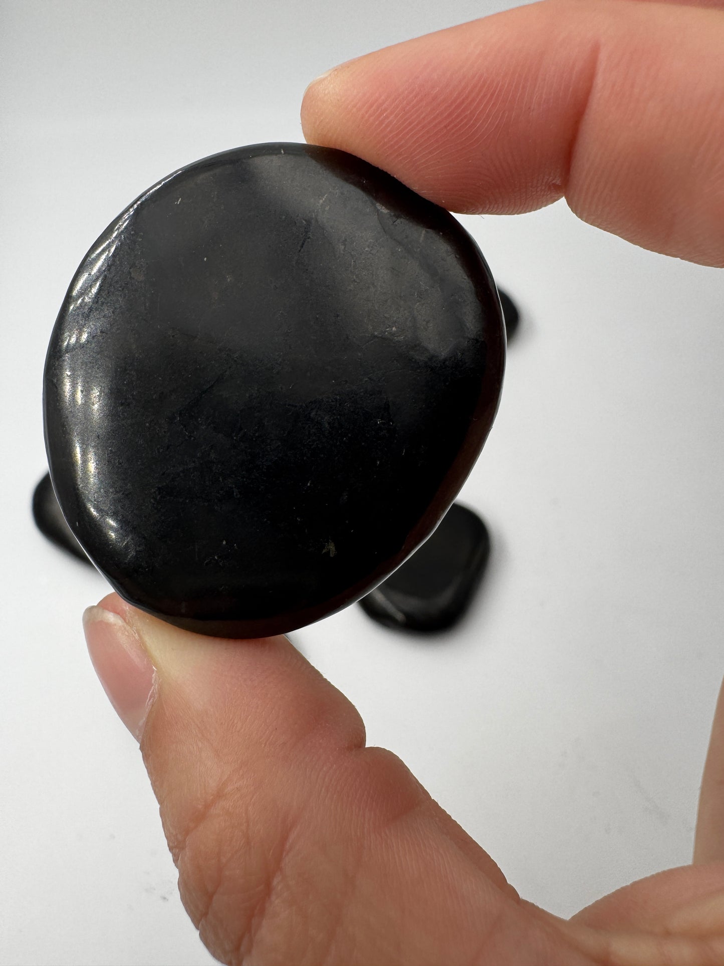 Scheibenstein aus Shungit, ca. 4 cm – seltenes kohlenstoffreiches Gestein aus Karelien, tiefes Mattschwarz, über 2 Milliarden Jahre alt.