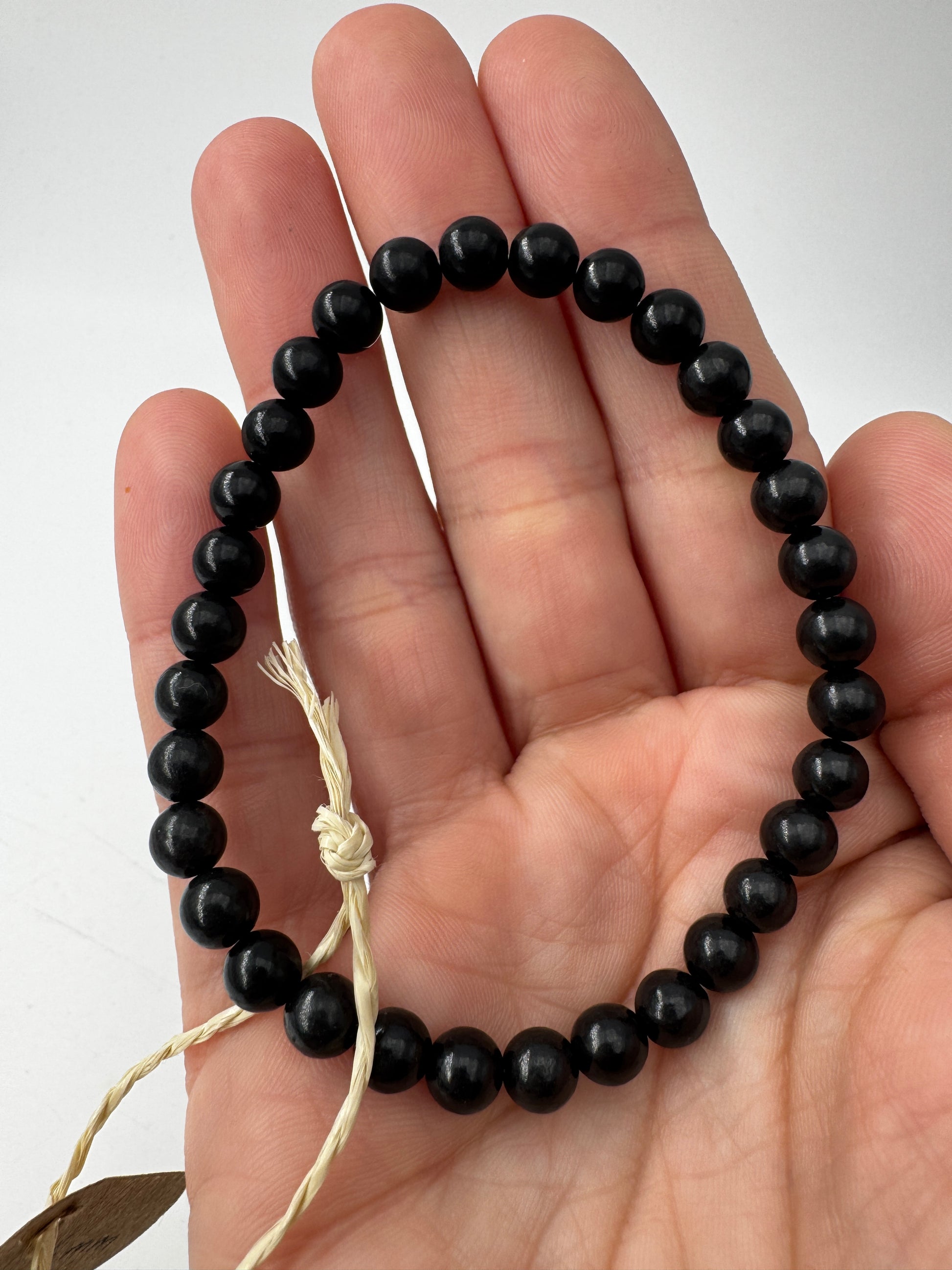 Shungit Armband SA21, 6 mm Kugeln, Umfang 19 cm – kohlenstoffreiches Gestein aus Karelien, tiefes Mattschwarz als Naturschmuck.