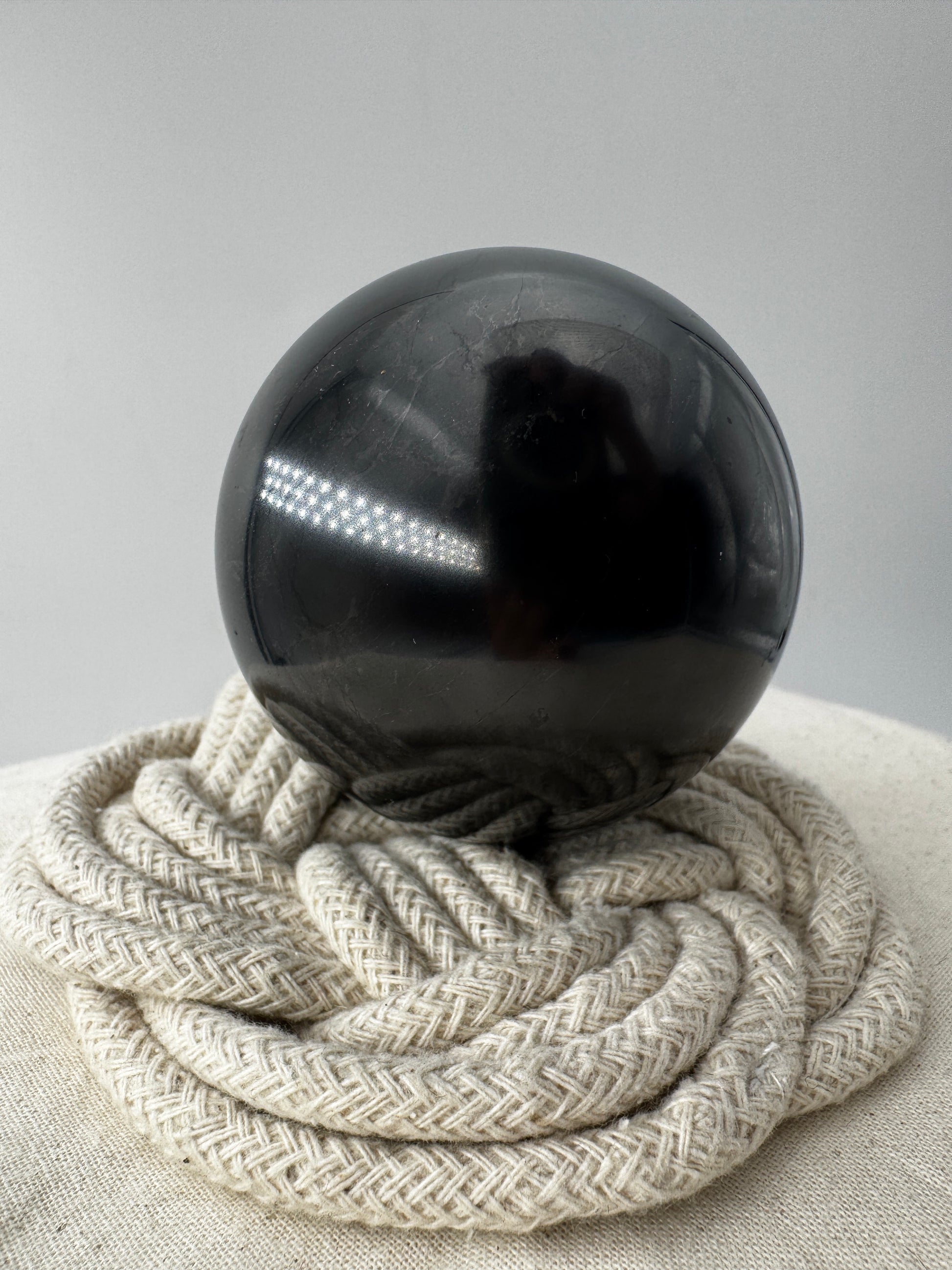 Eine perfekt runde, tiefschwarze Kugel aus poliertem Shungit.