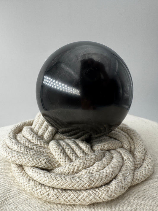 Eine perfekt runde, tiefschwarze Kugel aus poliertem Shungit.