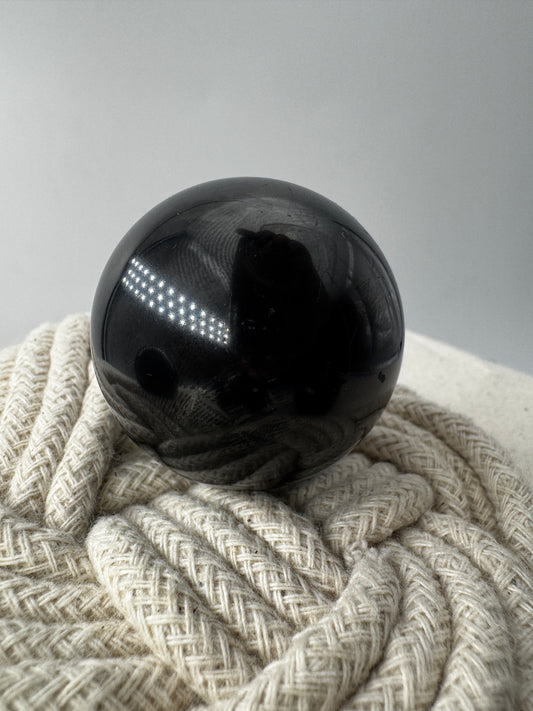 Eine perfekt runde, tiefschwarze Kugel aus poliertem Shungit.