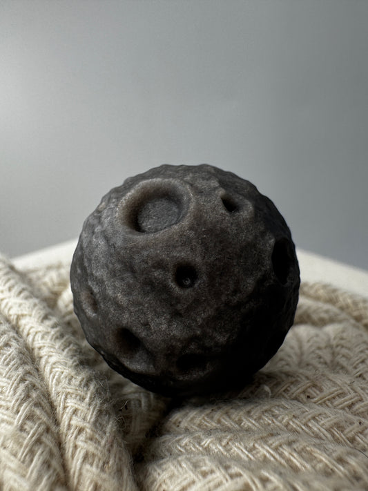 Silber-Obsidian-Mond mit haptischen Kratern und silbrigem Chatoyance-Effekt.
