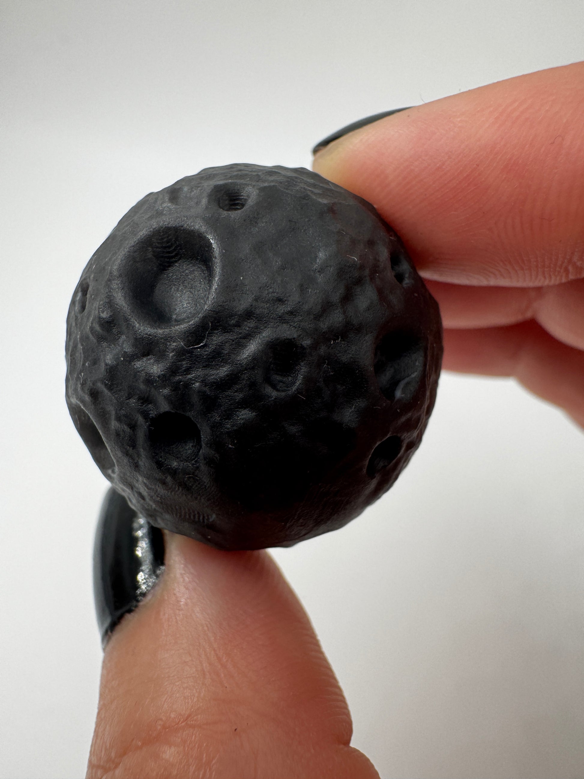 Silber-Obsidian-Mond mit haptischen Kratern und silbrigem Chatoyance-Effekt.