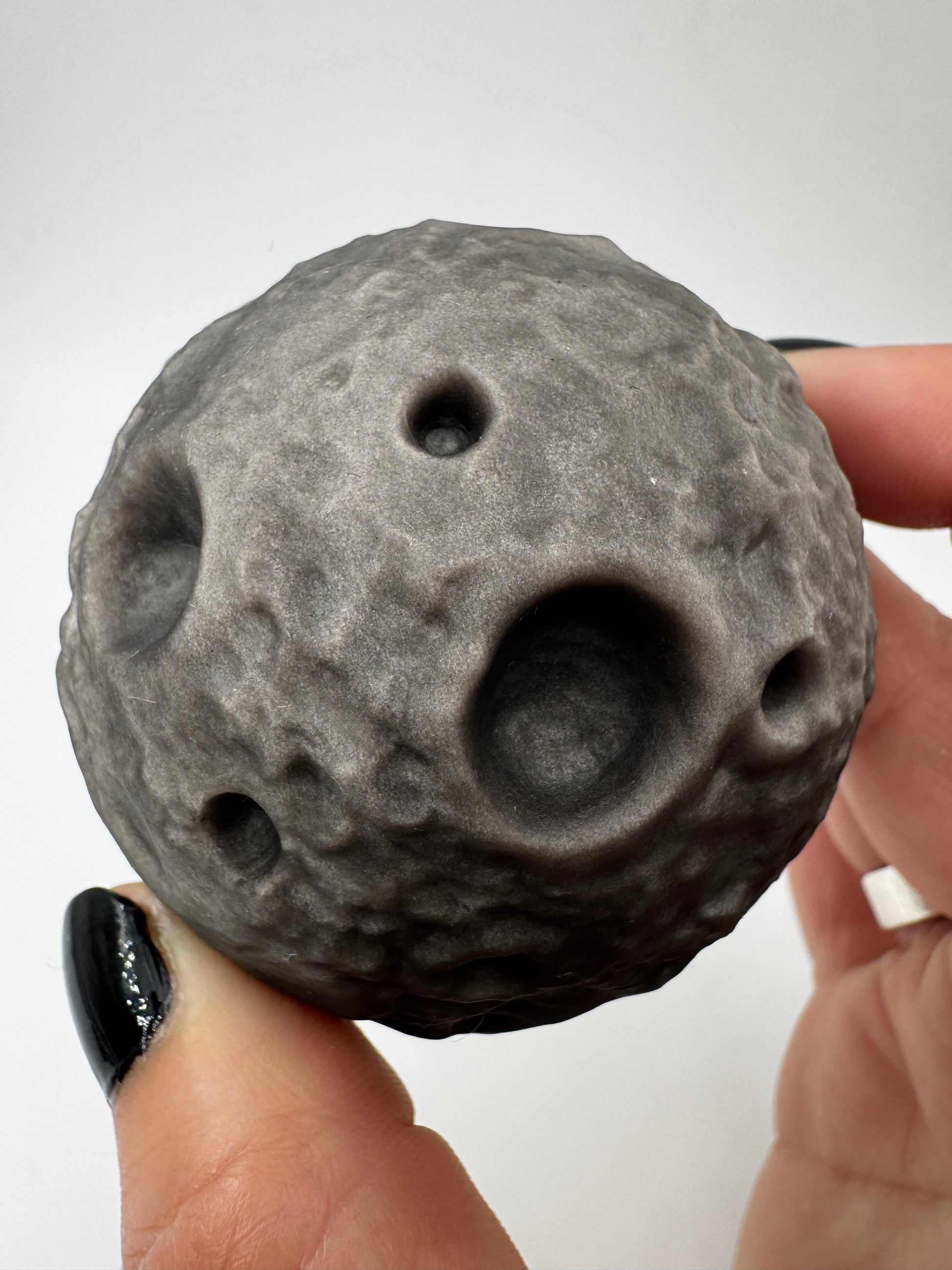 Silber-Obsidian-Mond mit haptischen Kratern und silbrigem Chatoyance-Effekt.