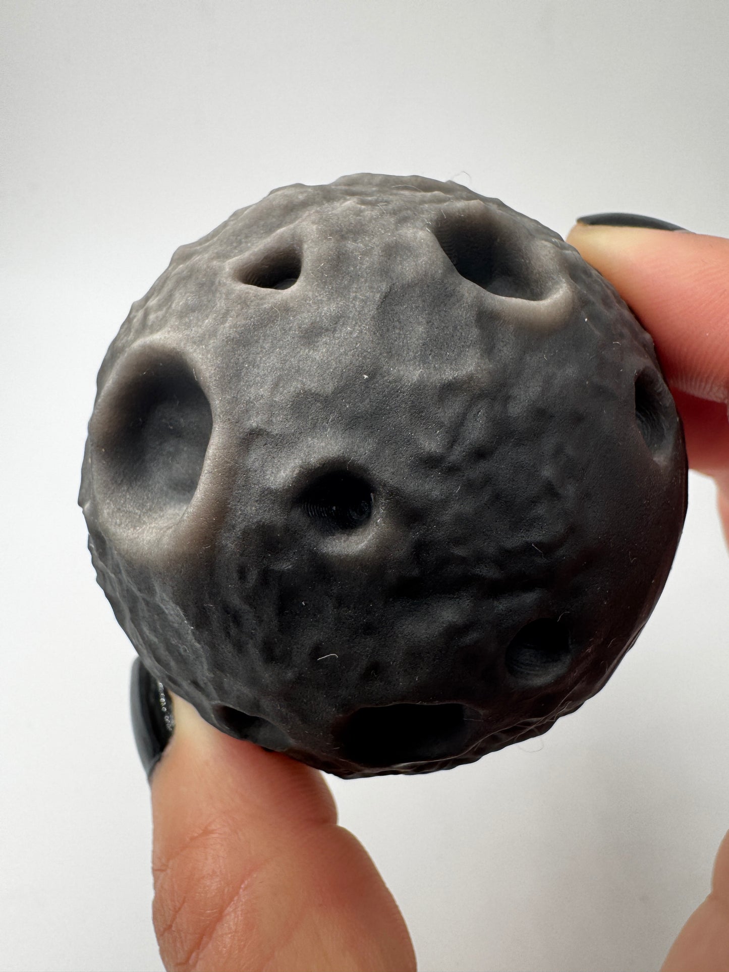 Silber-Obsidian-Mond mit haptischen Kratern und silbrigem Chatoyance-Effekt.