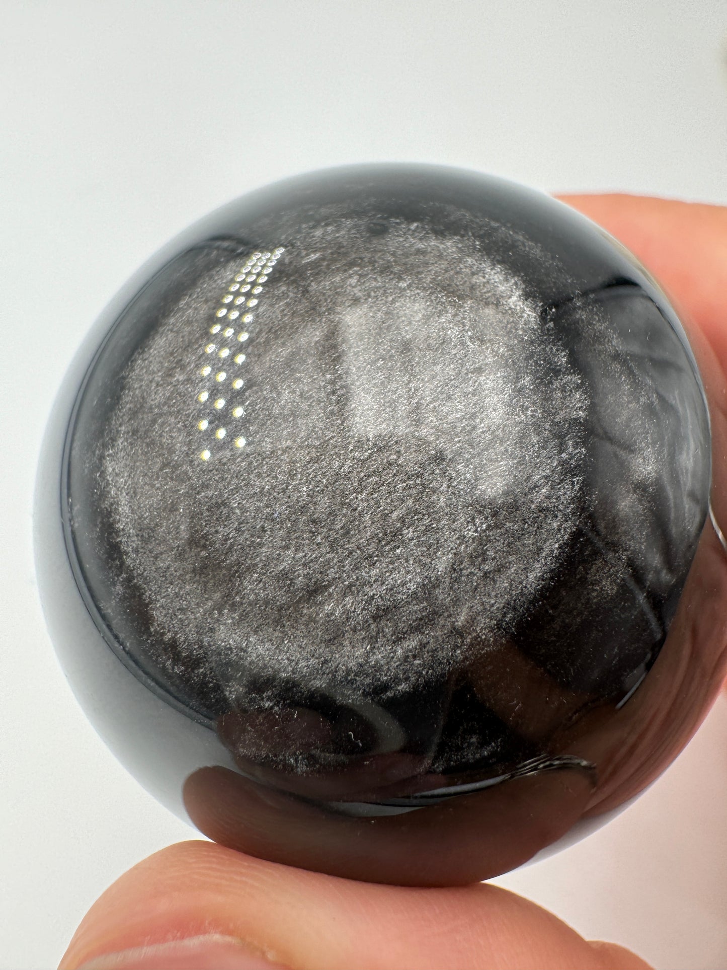 Polierte Silberobsidian Kugel, Ø 4,9 cm, mit charakteristischem silbrigem Seidenglanz auf schwarzem vulkanischem Glas
