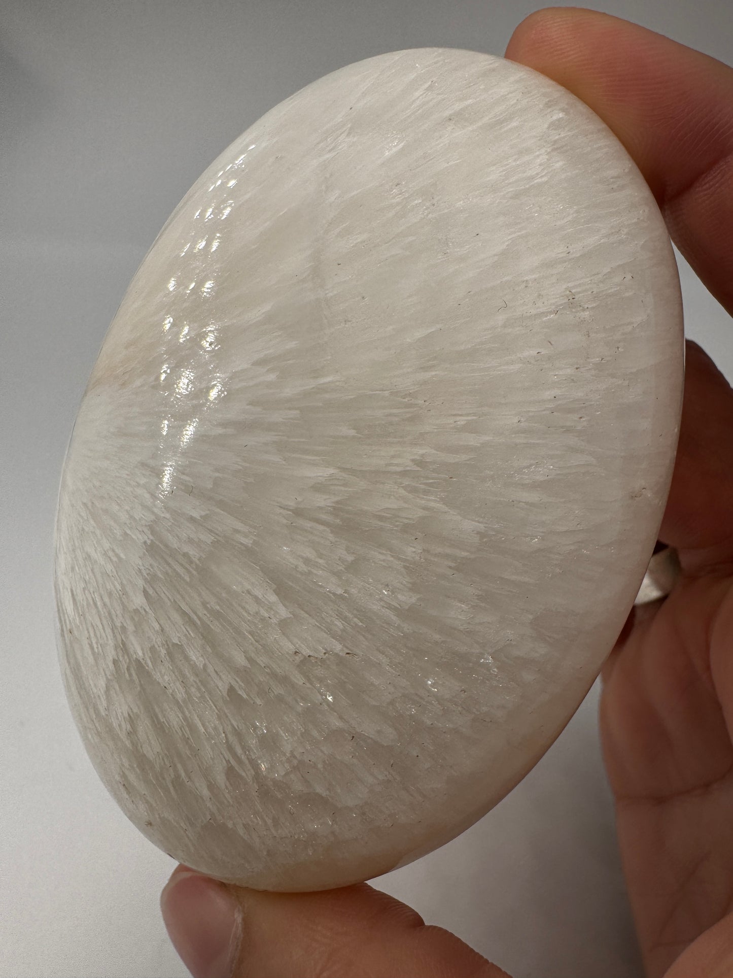 Großer Handstein aus Skolezit, 8,2–8,6 cm – seidig-weiße, nadelartige Kristallbüschel mit perlmutartigem Glanz auf natürlicher Gesteinsmatrix.
