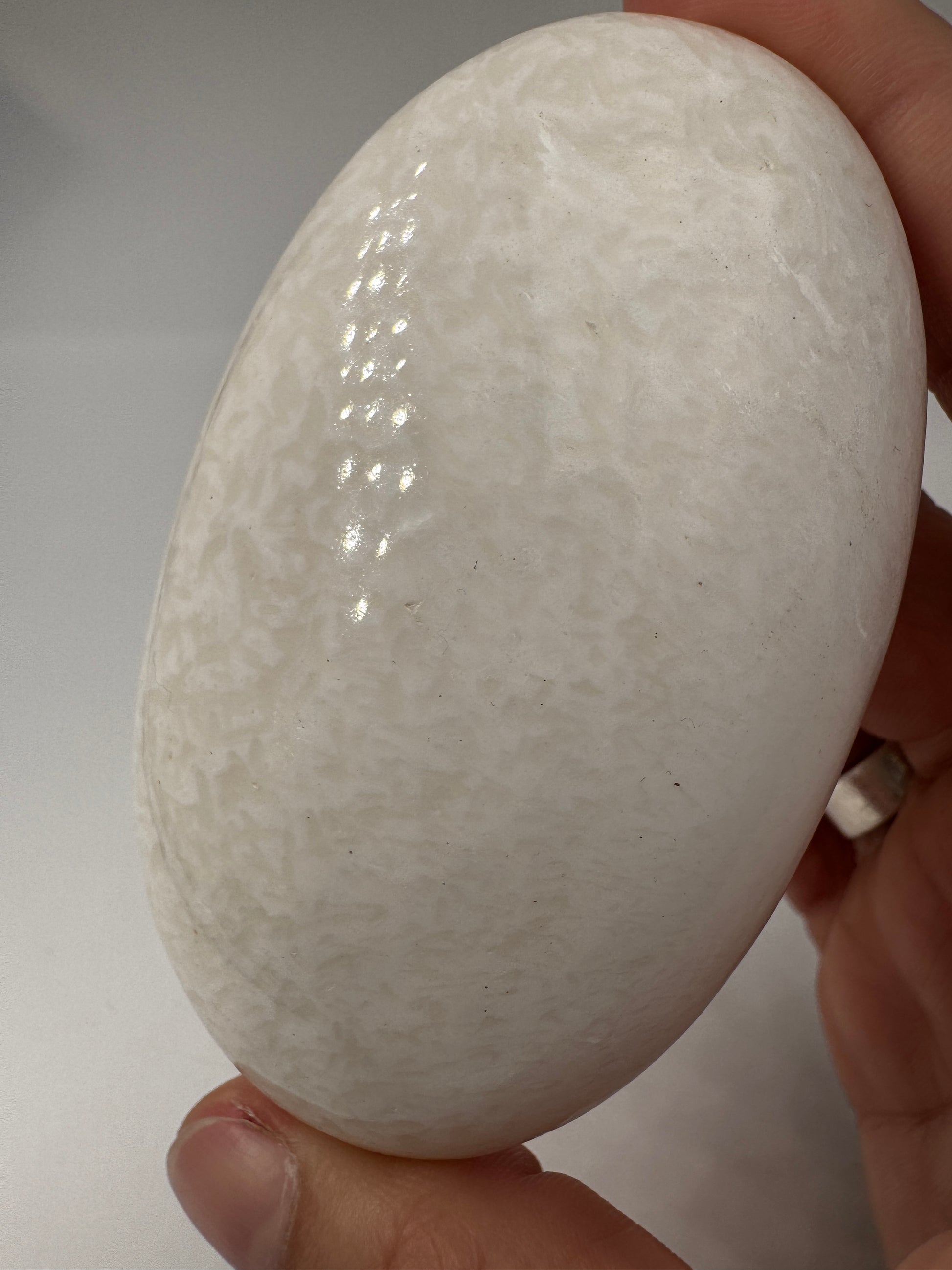 Großer Handstein aus Skolezit, 8,2–8,6 cm – seidig-weiße, nadelartige Kristallbüschel mit perlmutartigem Glanz auf natürlicher Gesteinsmatrix.