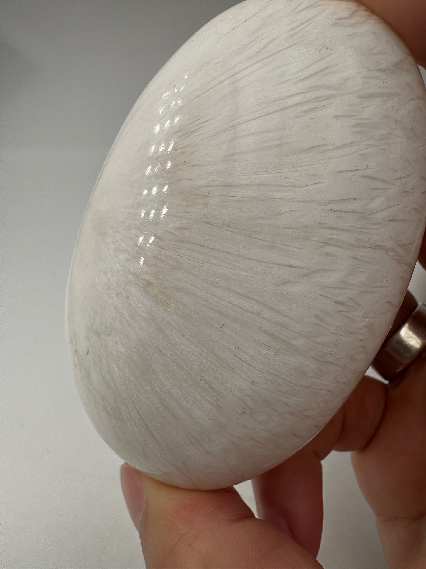 Großer Handstein aus Skolezit, 8,2–8,6 cm – seidig-weiße, nadelartige Kristallbüschel mit perlmutartigem Glanz auf natürlicher Gesteinsmatrix.