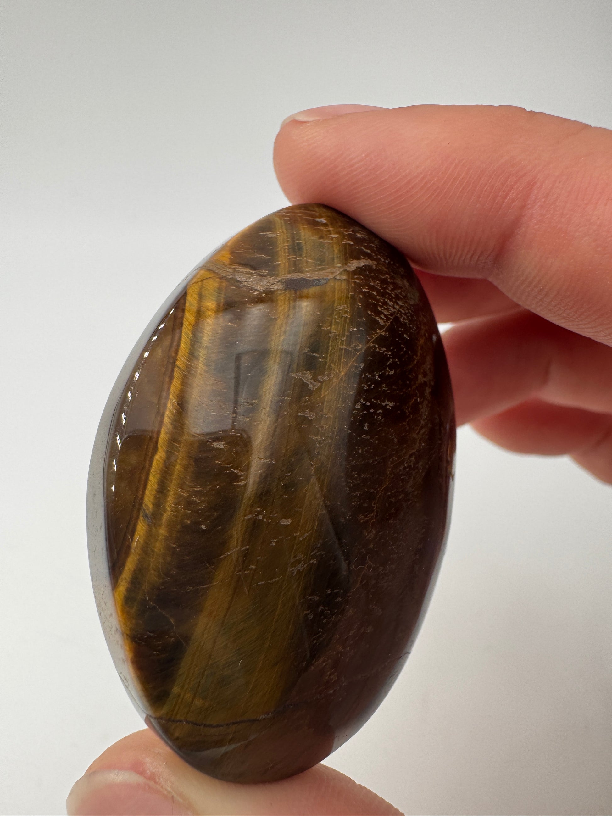 Tigerauge-Handstein TH12, 5×3,5 cm – polierter Quarz-Pseudomorphose in Goldbraun mit charakteristischem Chatoyance-Effekt (Seidenglanz), mineralogischer Klassiker.