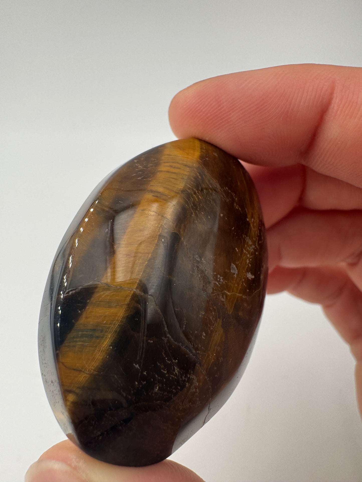Tigerauge-Handstein TH12, 5×3,5 cm – polierter Quarz-Pseudomorphose in Goldbraun mit charakteristischem Chatoyance-Effekt (Seidenglanz), mineralogischer Klassiker.