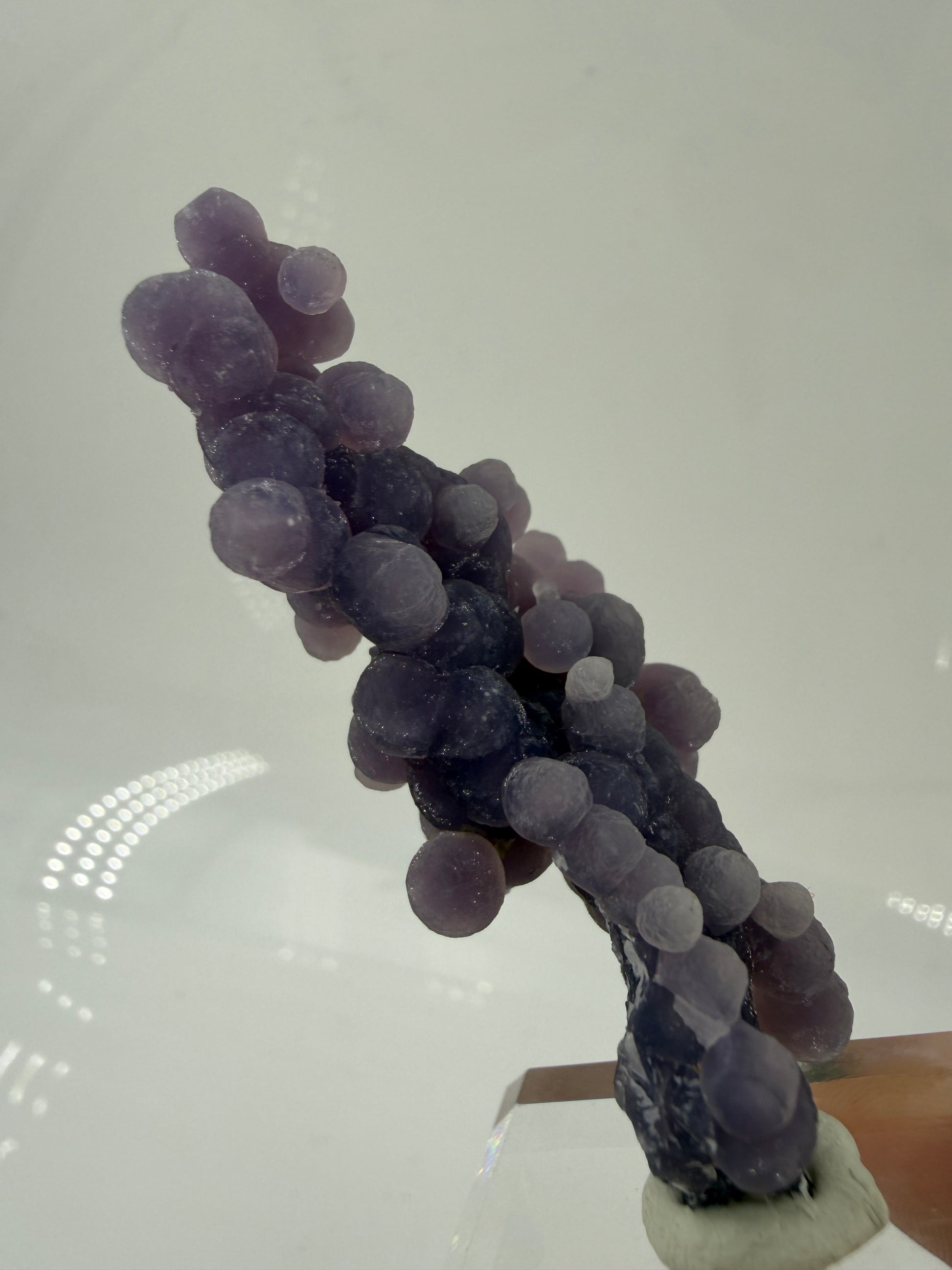 Nahaufnahme der traubenförmigen Struktur von lila Chalcedon, zeigt den glitzernden Drusy-Quarz-Überzug auf den Sphären.