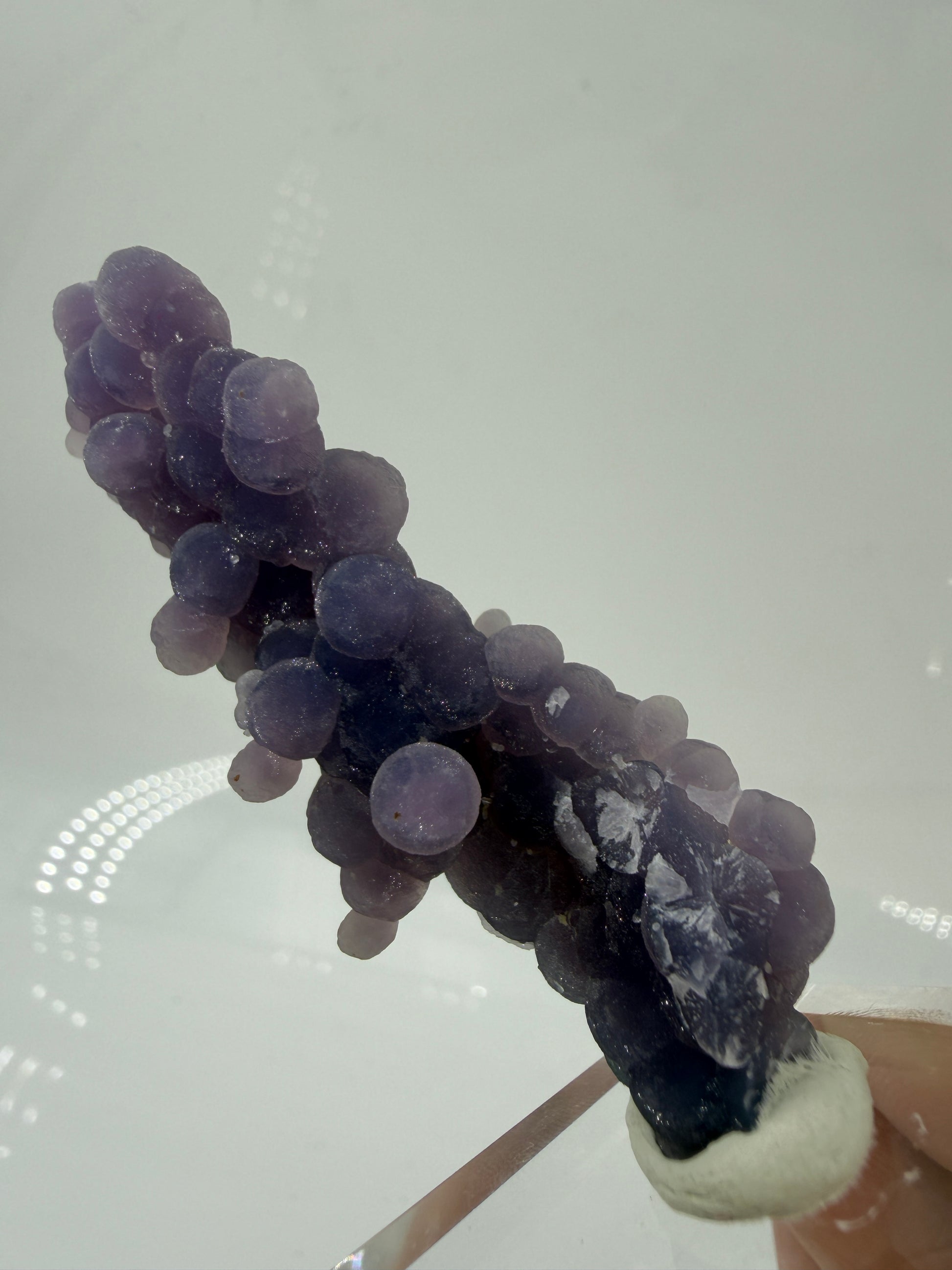 Nahaufnahme der traubenförmigen Struktur von lila Chalcedon, zeigt den glitzernden Drusy-Quarz-Überzug auf den Sphären.