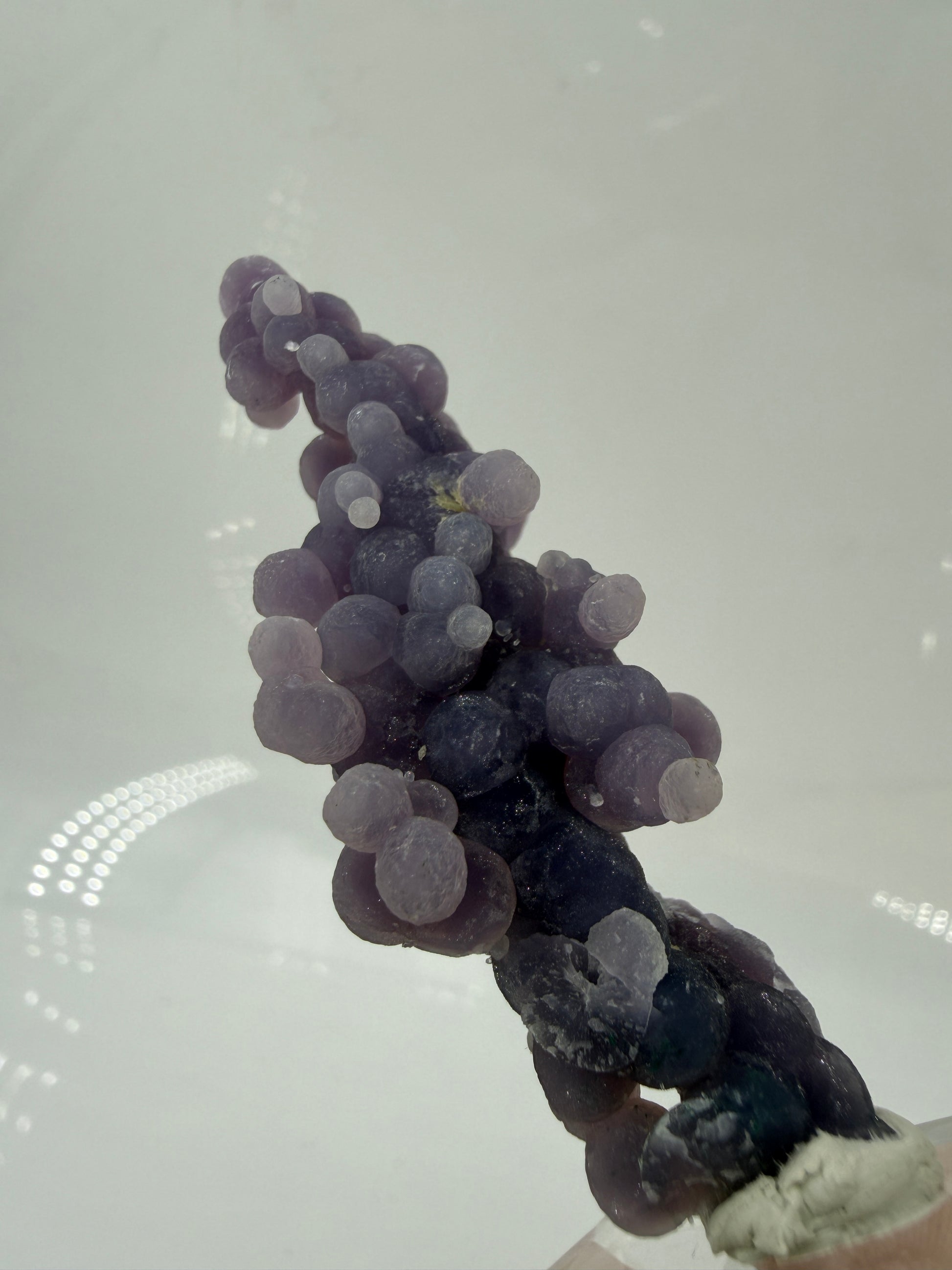 Nahaufnahme der traubenförmigen Struktur von lila Chalcedon, zeigt den glitzernden Drusy-Quarz-Überzug auf den Sphären.