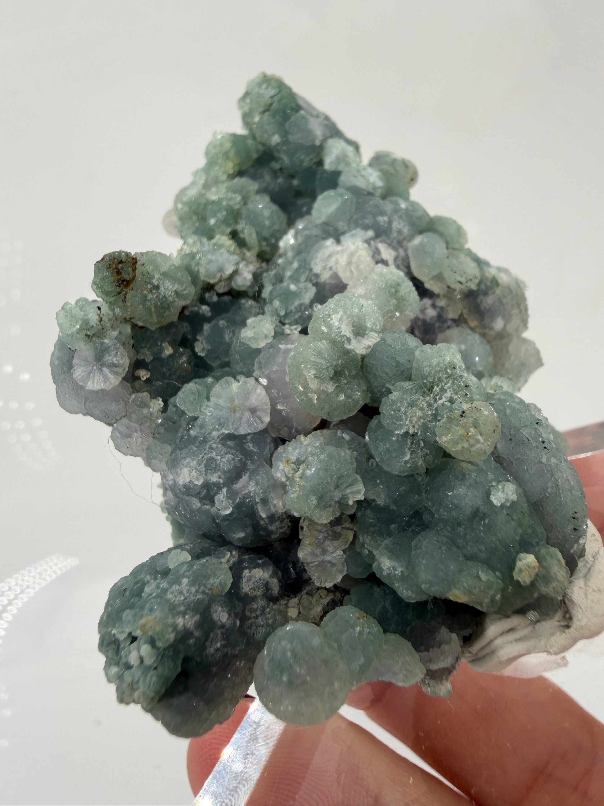 Nahaufnahme der traubenförmigen Struktur von grünem Chalcedon, zeigt den glitzernden Drusy-Quarz-Überzug auf den Sphären.