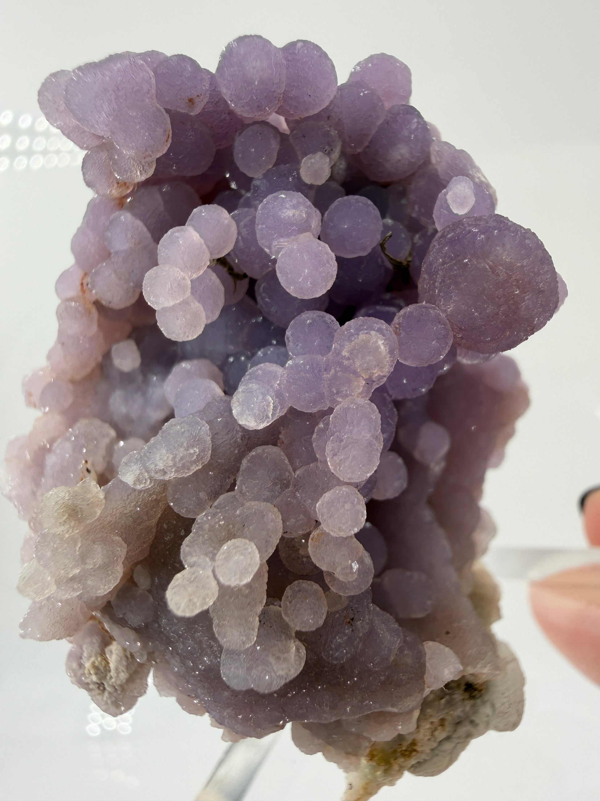 Nahaufnahme der traubenförmigen Struktur von lila Chalcedon, zeigt den glitzernden Drusy-Quarz-Überzug auf den Sphären.