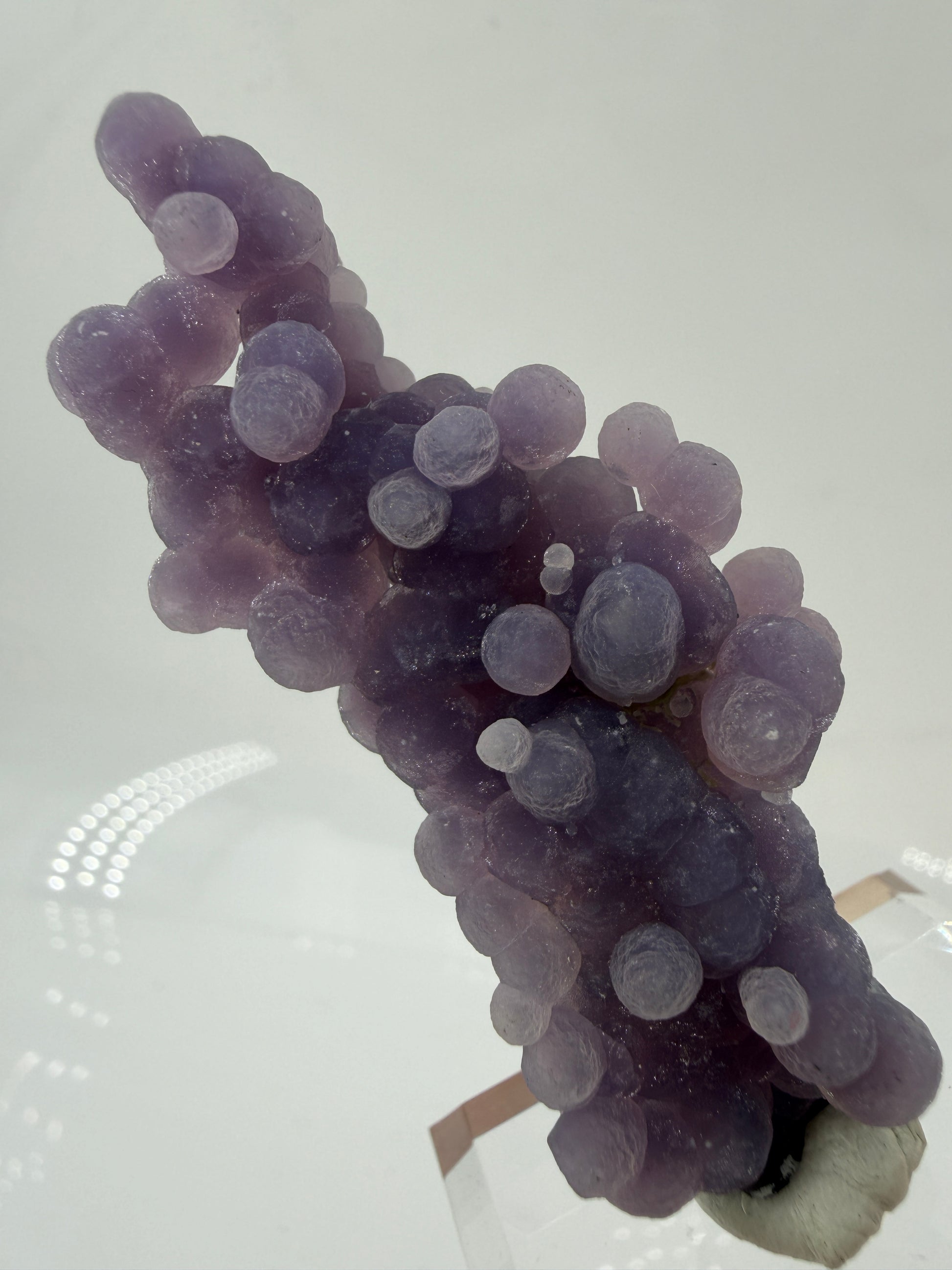 Nahaufnahme der traubenförmigen Struktur von lila Chalcedon, zeigt den glitzernden Drusy-Quarz-Überzug auf den Sphären.