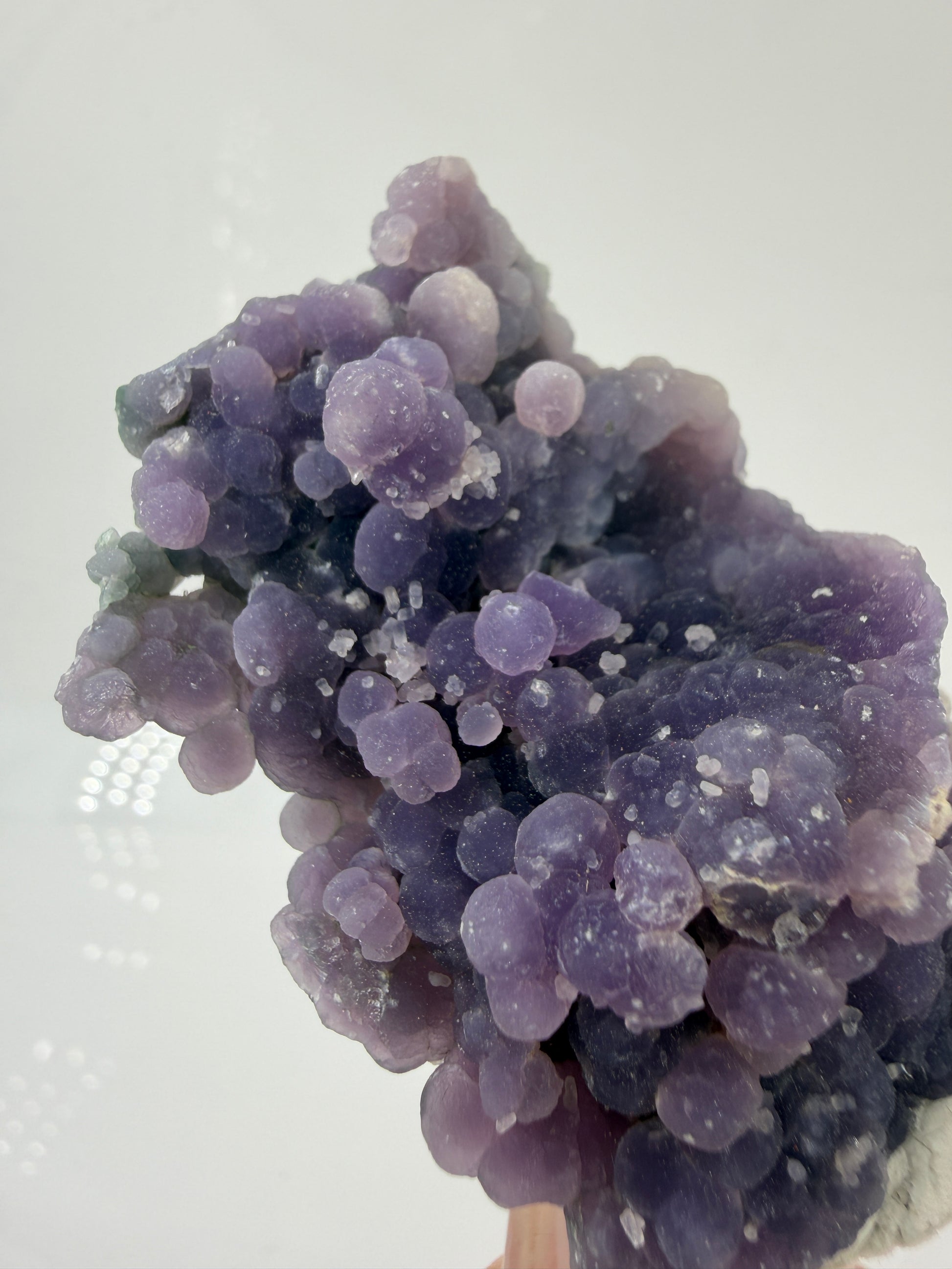 Nahaufnahme der traubenförmigen Struktur von lila/grün Chalcedon, zeigt den glitzernden Drusy-Quarz-Überzug auf den Sphären.