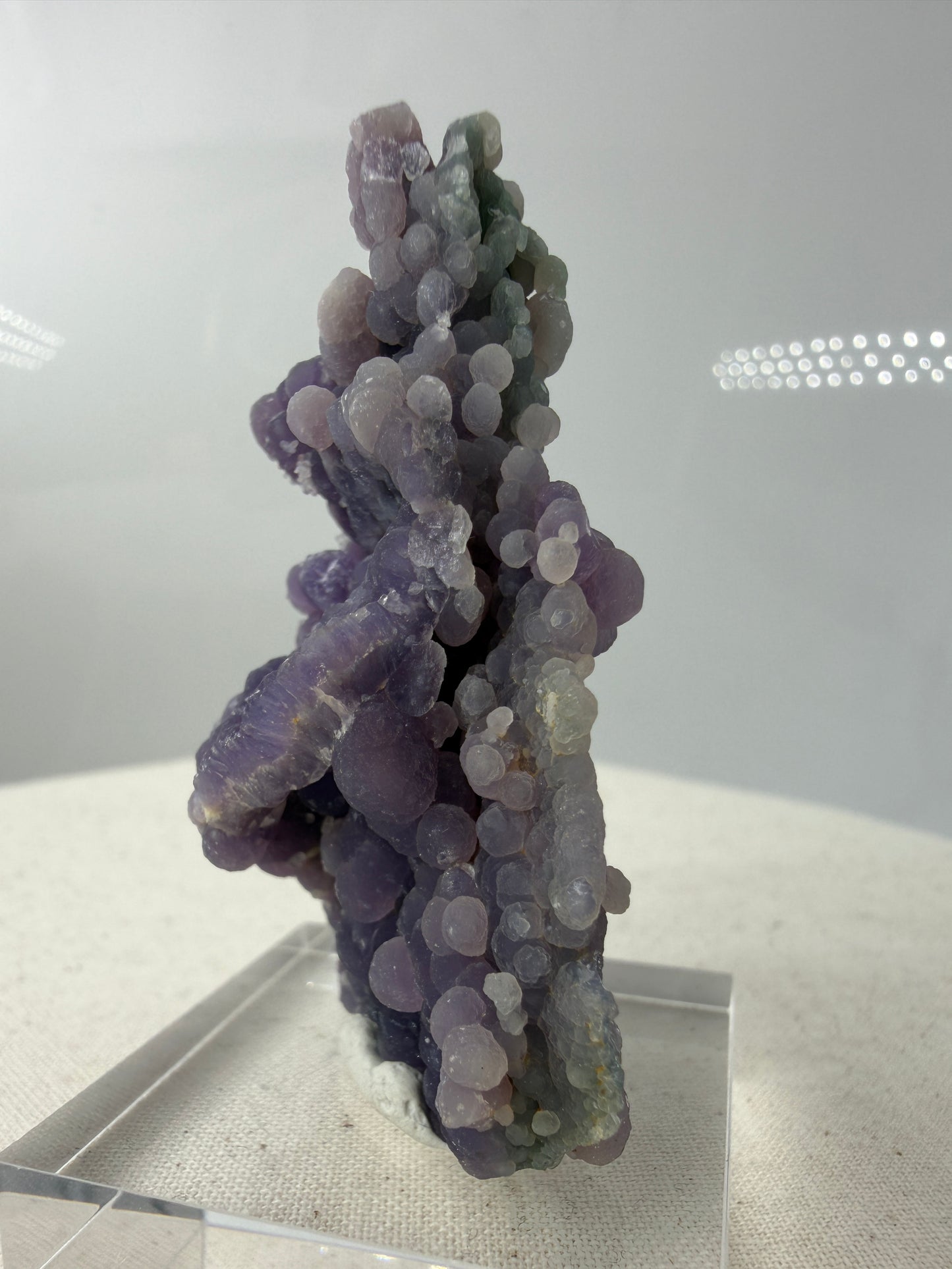Seitenansicht das Botryoidaler Chalcedon (Traubenachat) aus Mamuju, Sulawesi, violettes - grünes Kristall-Cluster mit kugelförmigen Aggregaten.