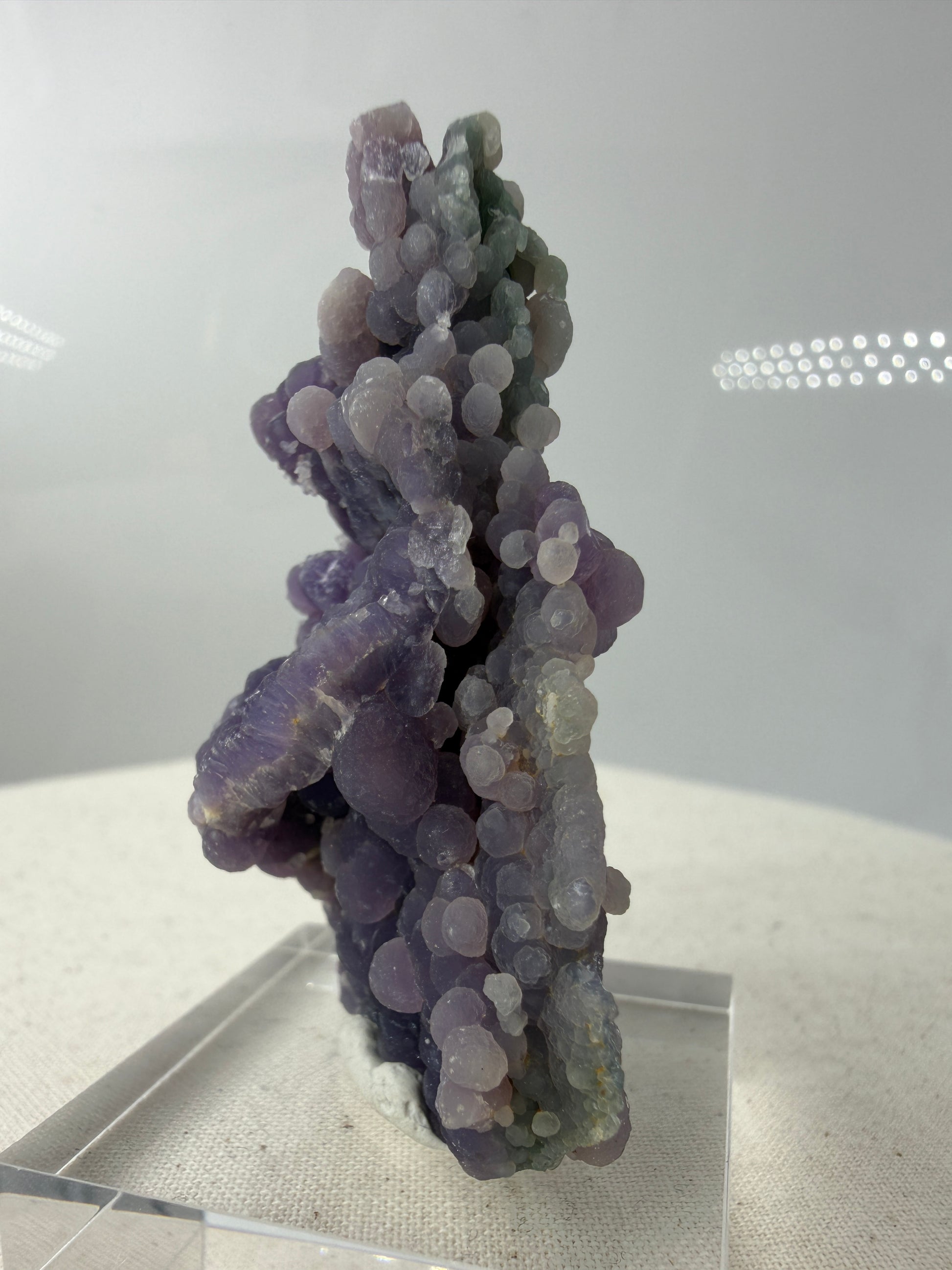 Seitenansicht das Botryoidaler Chalcedon (Traubenachat) aus Mamuju, Sulawesi, violettes - grünes Kristall-Cluster mit kugelförmigen Aggregaten.