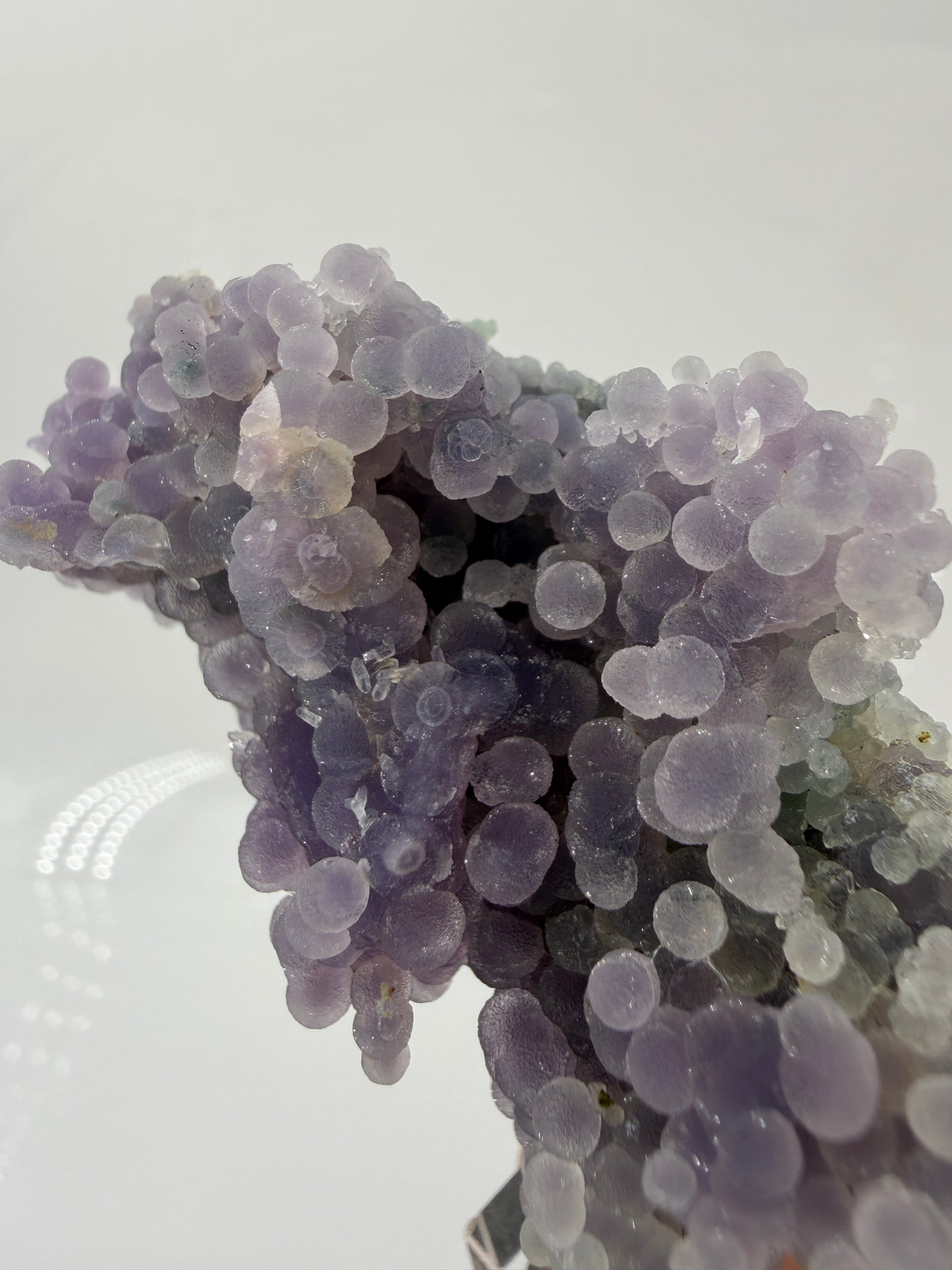 Nahaufnahme der traubenförmigen Struktur von lila Chalcedon, zeigt den glitzernden Drusy-Quarz-Überzug auf den Sphären.