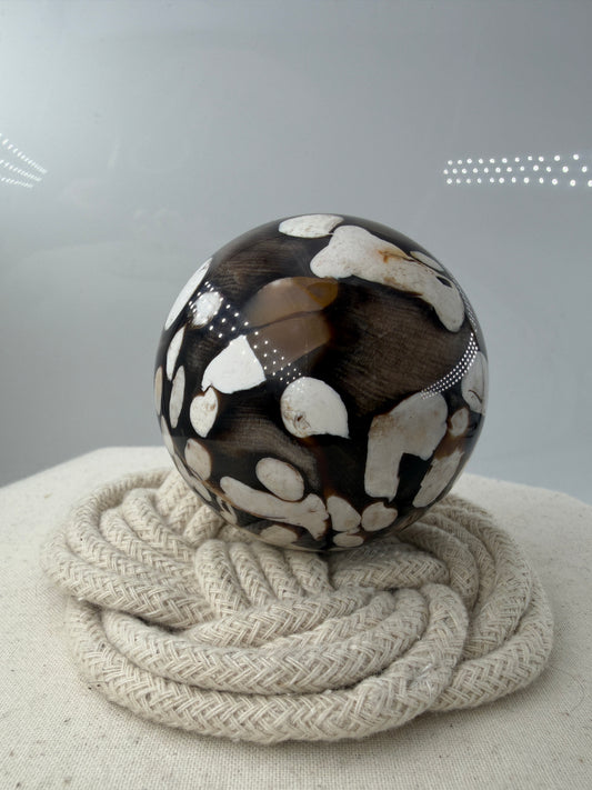 Peanut Jasper Kugel, poliertes versteinertes Holz mit kontrastreichen hellen Einschlüssen fossiler Bohrkanäle.