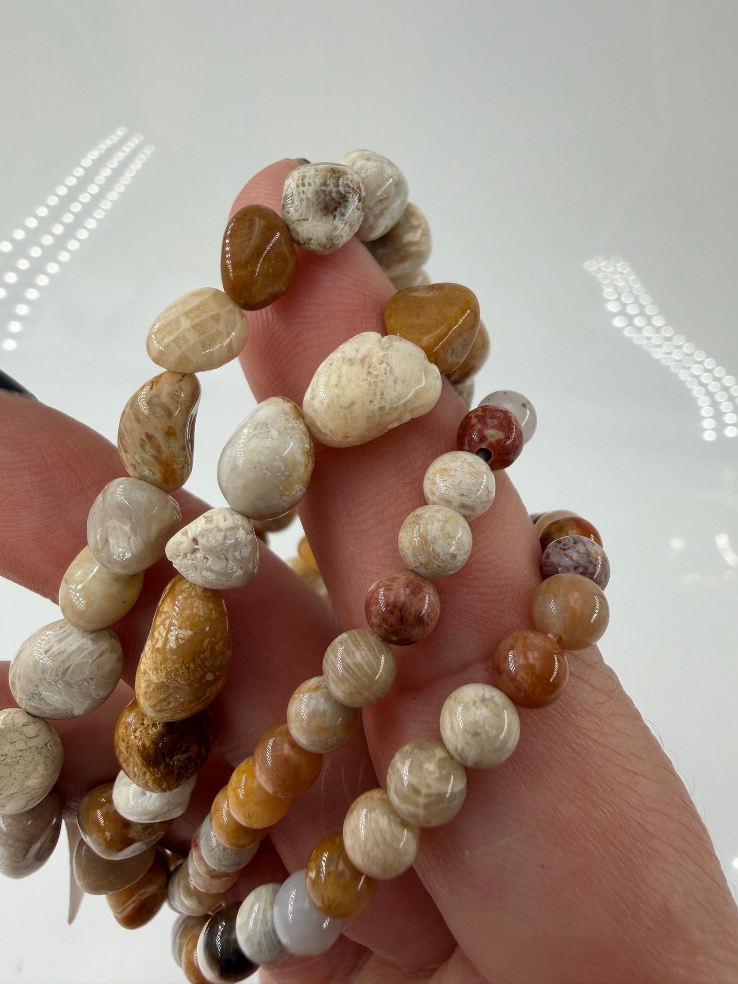 Elastisches Armbänder aus versteinerter Koralle (Petrosit) mit natürlicher Farbpalette.