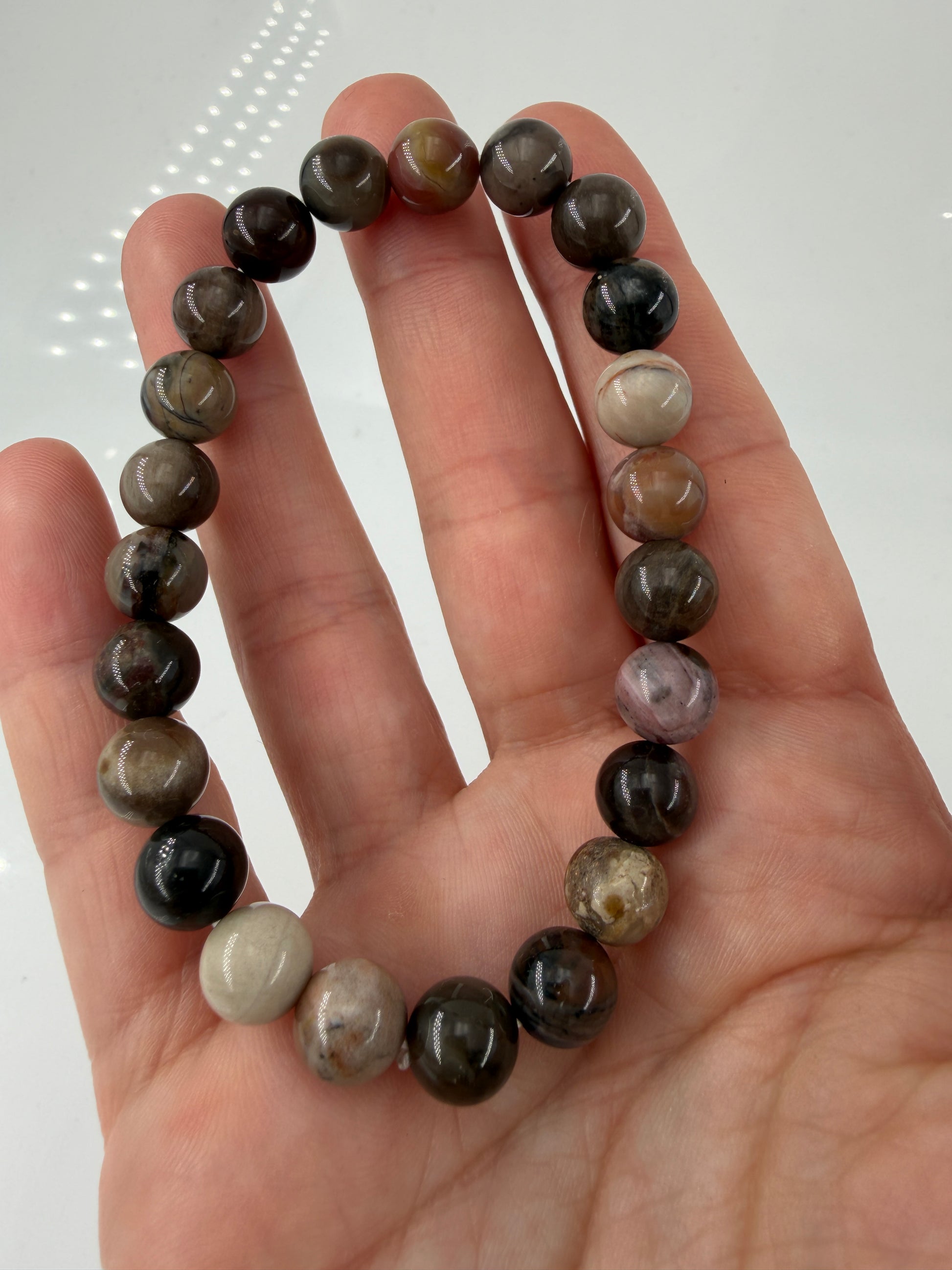 Elastisches Kugelarmband aus versteinertem Holz (Xylolith) mit natürlicher Holzmaserung als Pseudomorphose.