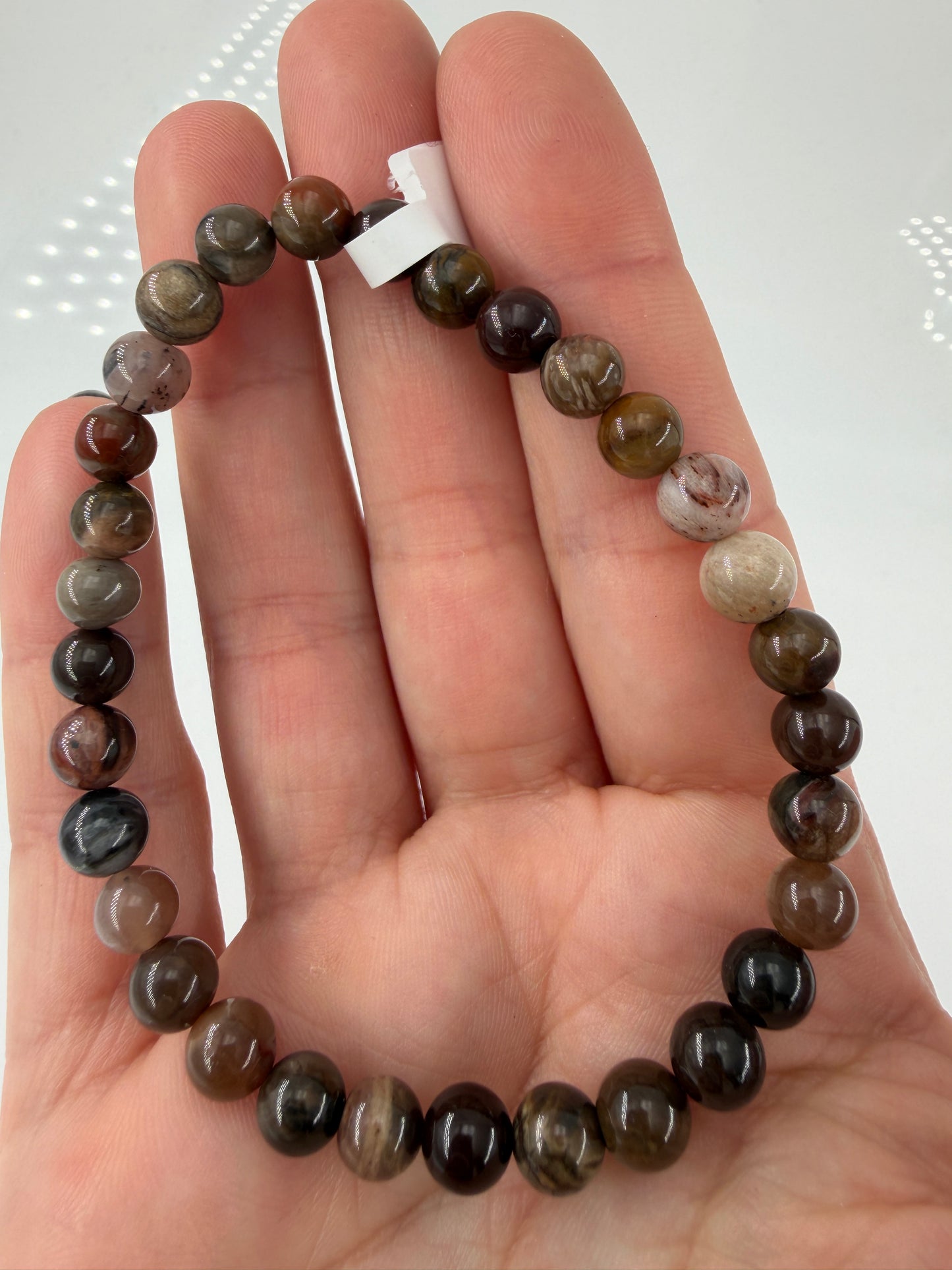 Elastisches Kugelarmband aus versteinertem Holz (Xylolith) mit natürlicher Holzmaserung als Pseudomorphose.
