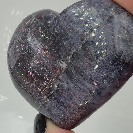 Ein Herz aus dunkelblauem Iolith, mit Sonnenstein. Die glatte Oberfläche zeigt je nach Lichteinfall einen metallischen Glanz und die charakteristischen Farbumschläge der beiden Mineralvarianten.