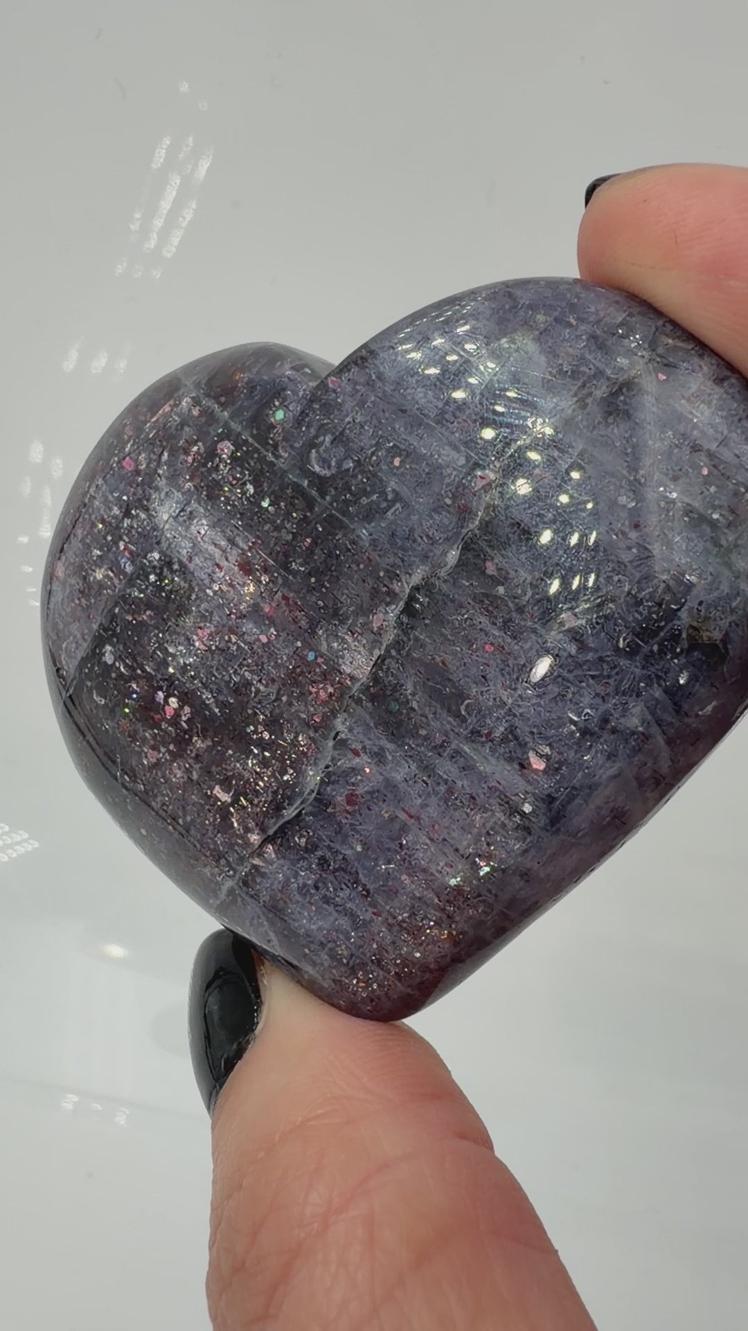 Ein Herz aus dunkelblauem Iolith, mit Sonnenstein. Die glatte Oberfläche zeigt je nach Lichteinfall einen metallischen Glanz und die charakteristischen Farbumschläge der beiden Mineralvarianten.