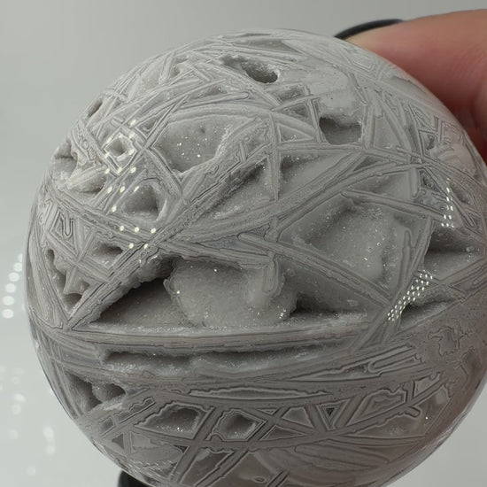 Handpolierte Lace Achat Kugel in Weiß und Grau mit natürlichen Drusen und charakteristischen Bänderungen, Ø 6,0 cm – edles Sammlerstück aus Quarz.