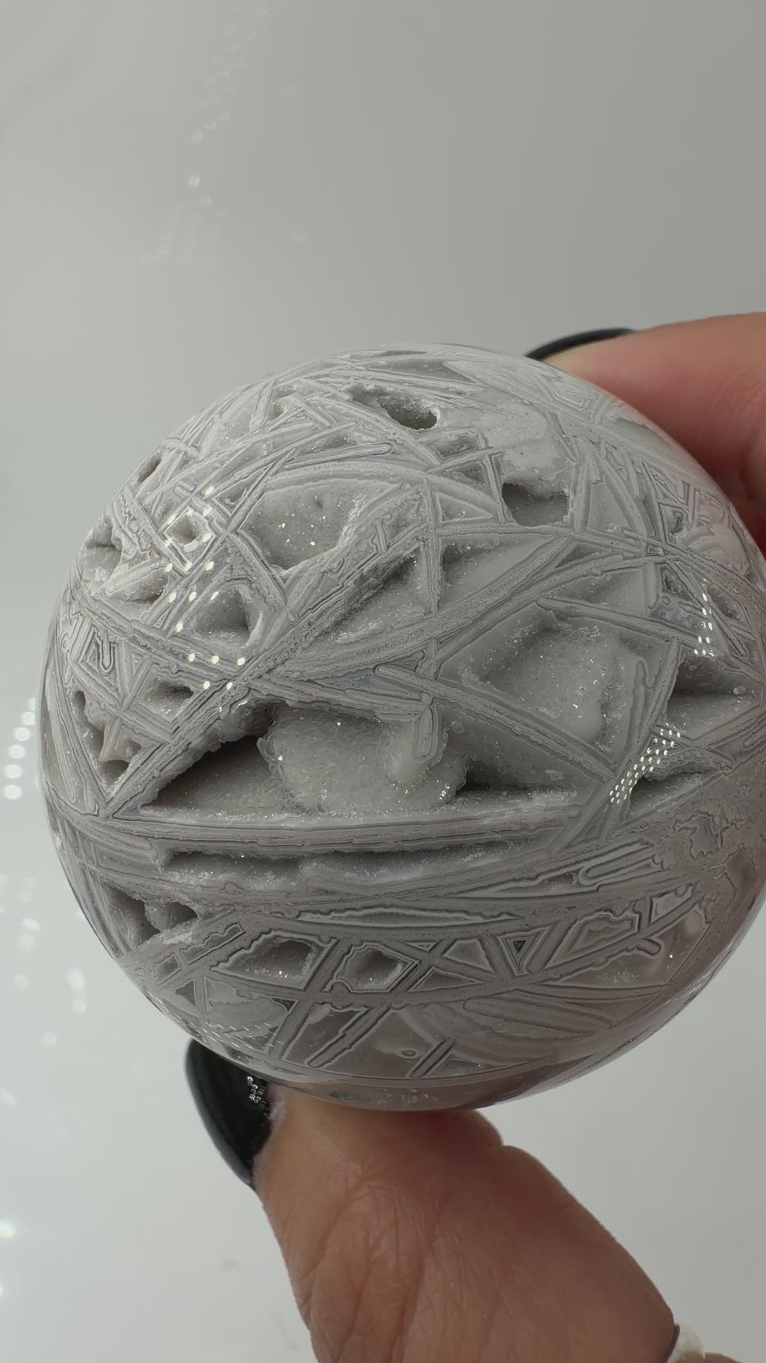 Handpolierte Lace Achat Kugel in Weiß und Grau mit natürlichen Drusen und charakteristischen Bänderungen, Ø 6,0 cm – edles Sammlerstück aus Quarz.