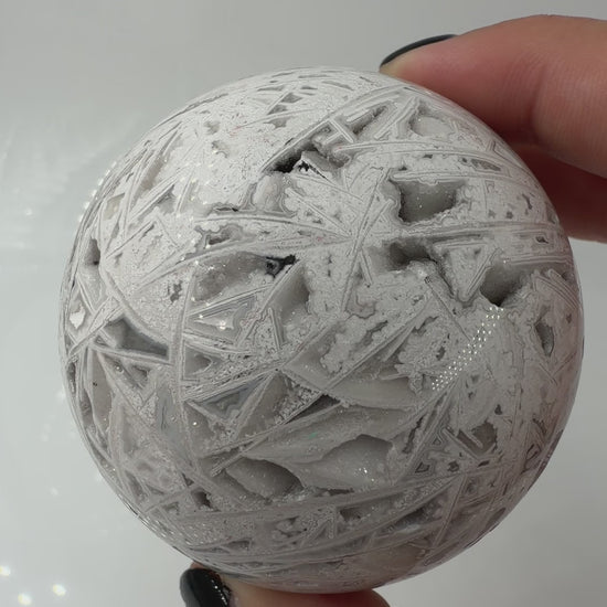 Handpolierte Lace Achat Kugel in Weiß und Grau mit natürlichen Drusen und charakteristischen Bänderungen, Ø 6,5 cm – edles Sammlerstück aus Quarz.