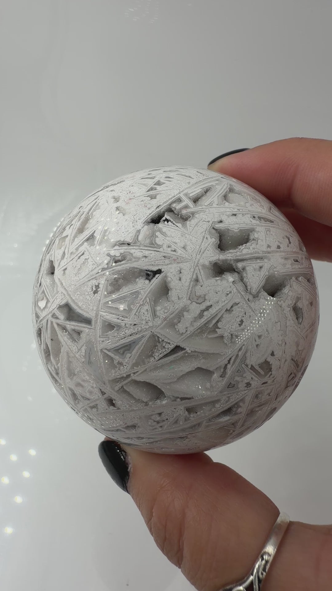 Handpolierte Lace Achat Kugel in Weiß und Grau mit natürlichen Drusen und charakteristischen Bänderungen, Ø 6,5 cm – edles Sammlerstück aus Quarz.